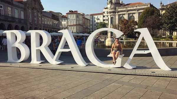 Me sat on a giant sign spelling out "Braga" in Portugal.