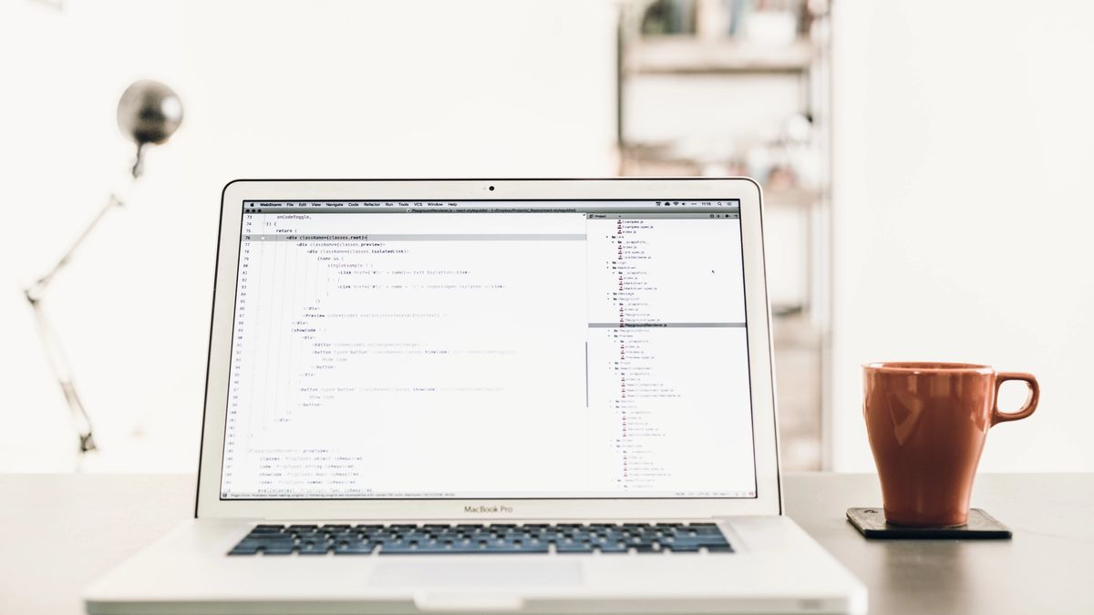 MacBook Pro showing code accompanied by a mug.