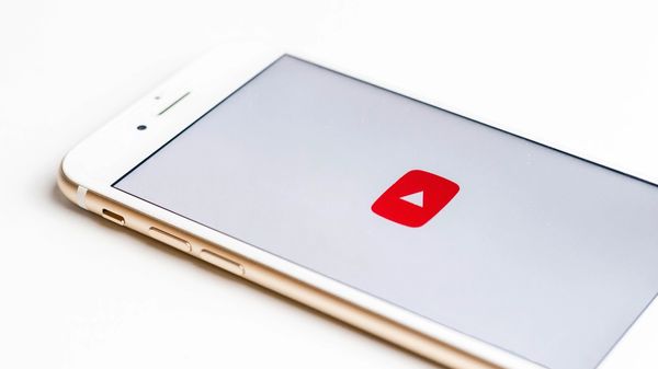 White iPhone displaying YouTube logo on white background