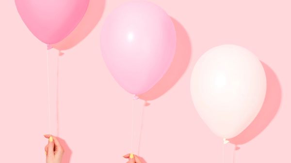 Three balloons in various shades of pink, on a pink background.