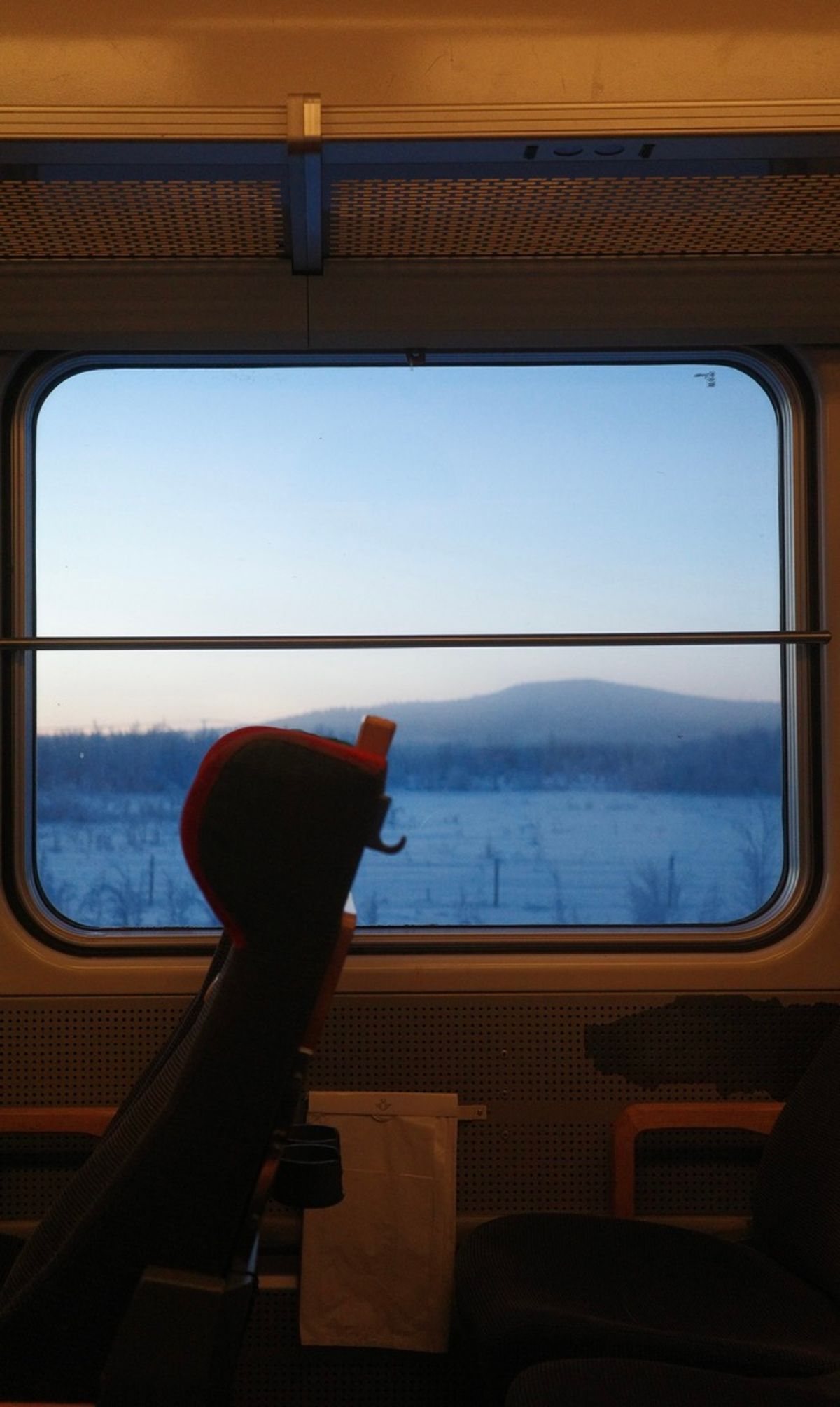 A snowy landscape seen through the window of a train