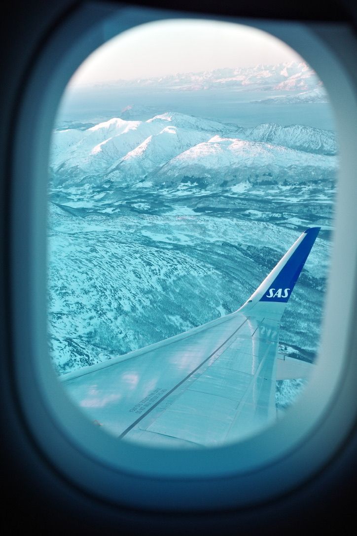 A snow-covered landscape seen through an airplane window