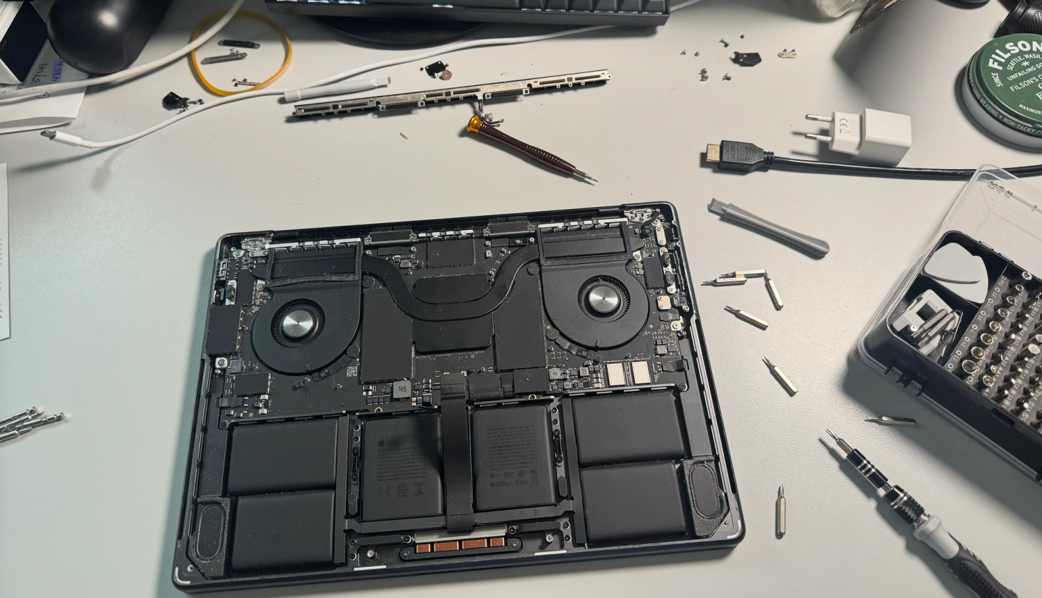 M4 Macbook open on desk. Tools and screws surround