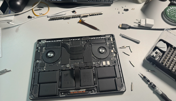 M4 Macbook open on desk. Tools and screws surround