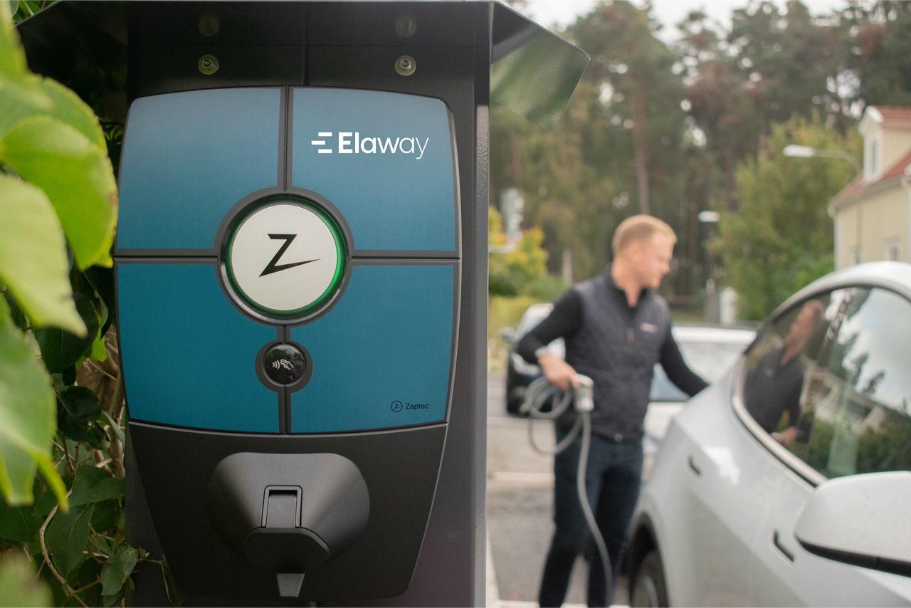 bilde av en utendørs elbillader, og en mann som lader elbilen