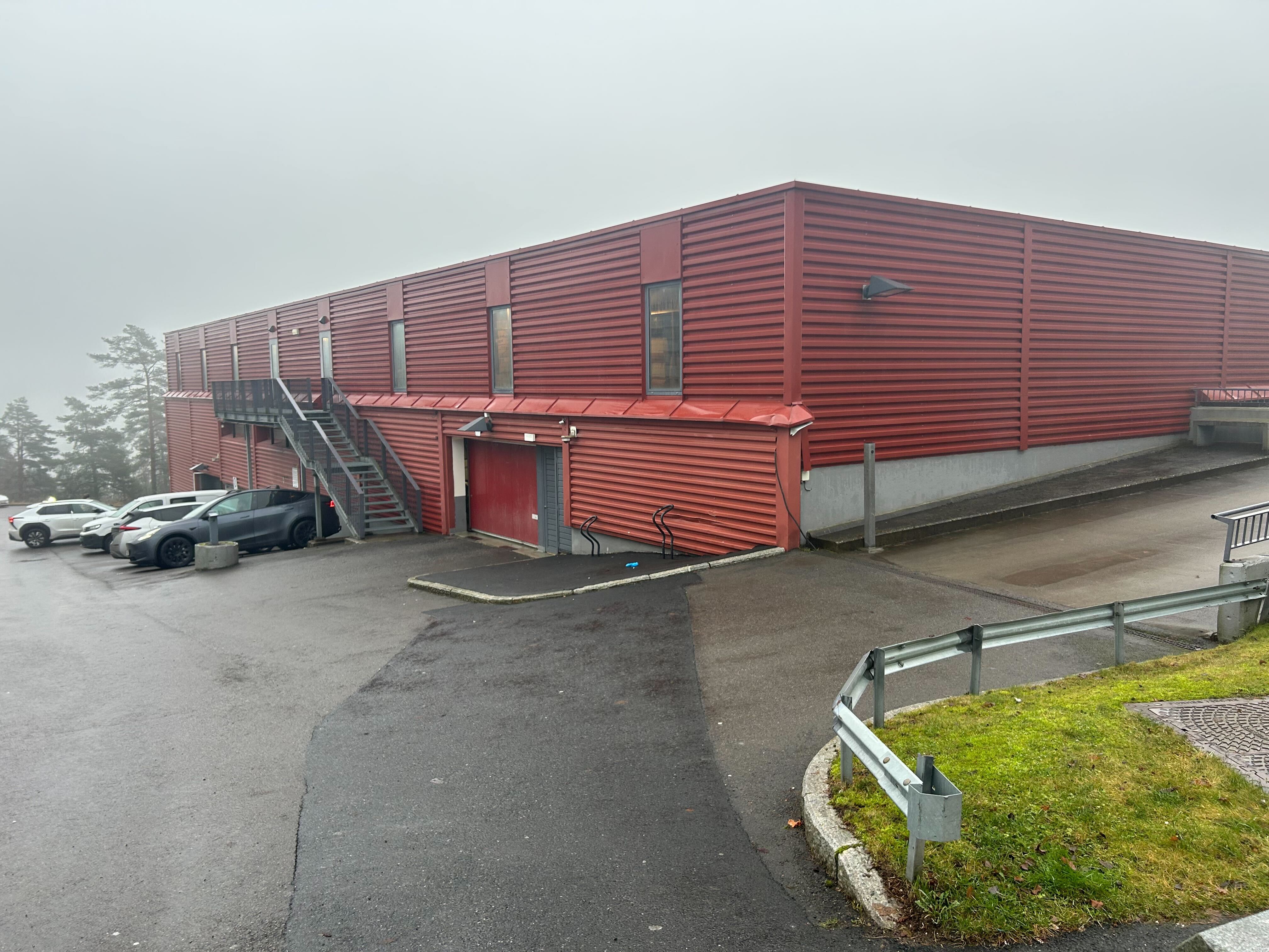 Utendørs foto av en rød parkeringsgarasje med biler utenfor