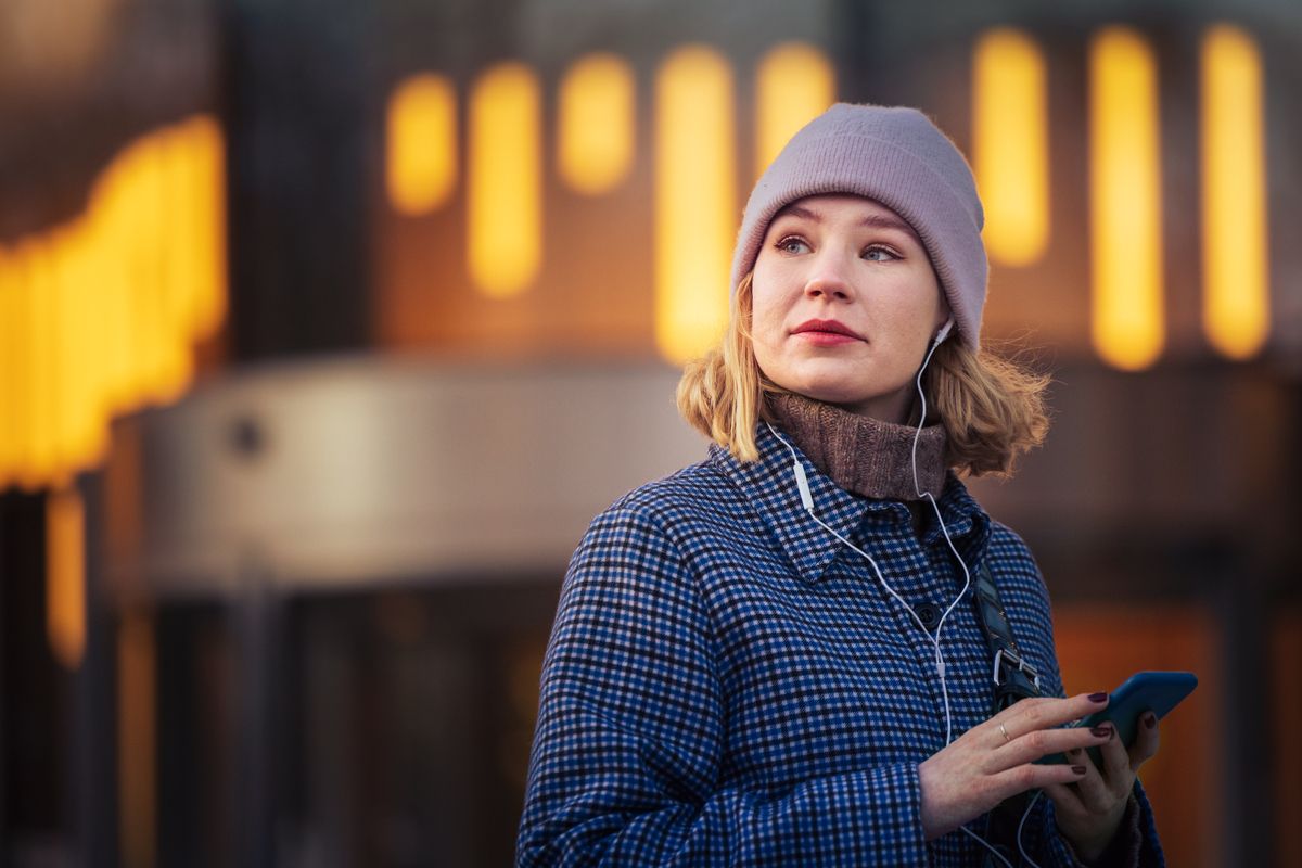 Foto av ung vinterkledd kvinne med mobiltelefon