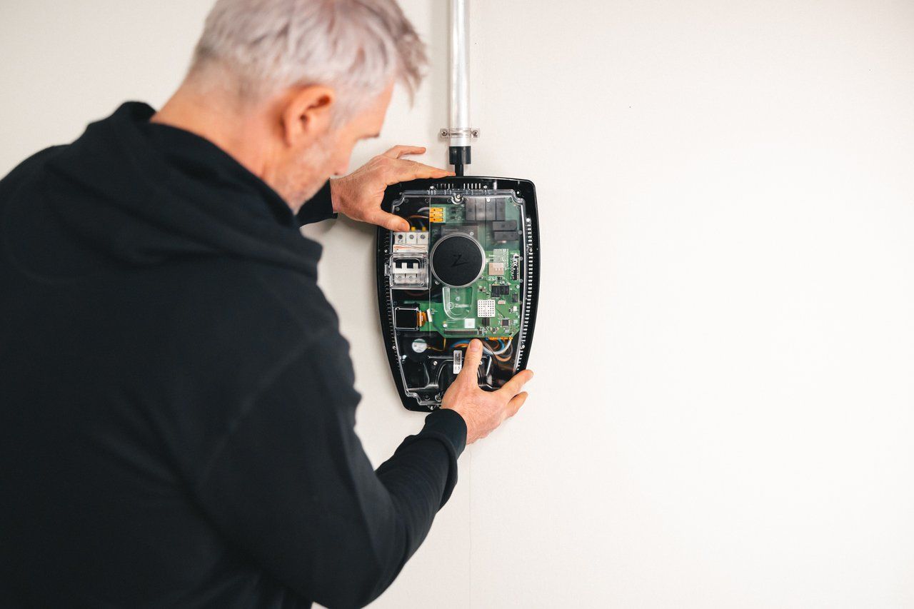 Foto av installatør som utfører service på en elbillader