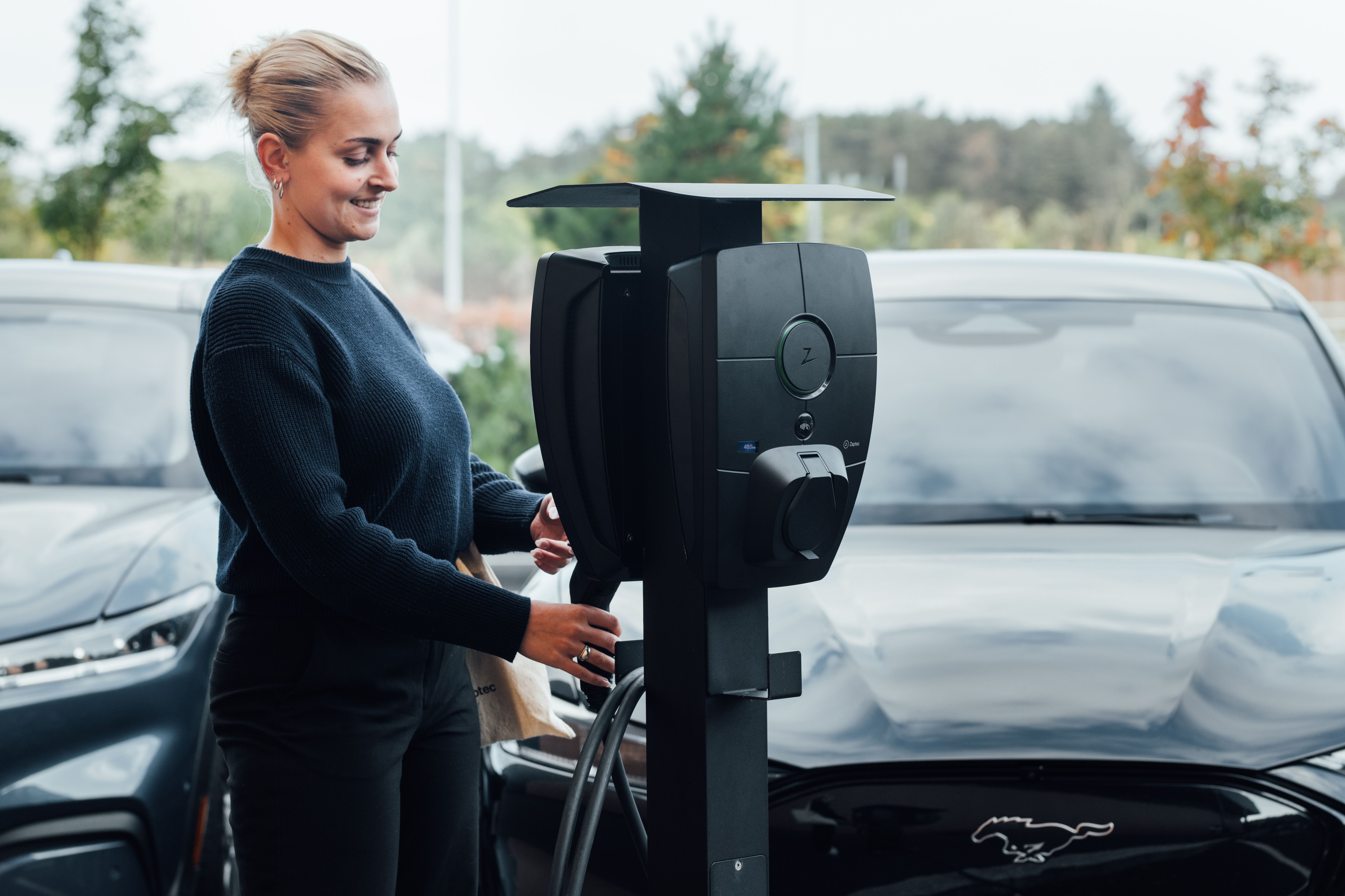 Bilde av en dame som plugger i en lader