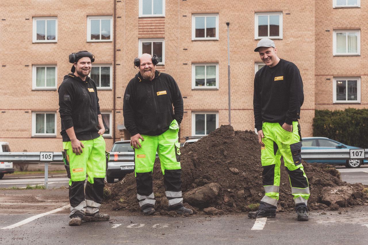 Bilde av 3 menn foran foran et leilighetskompleks