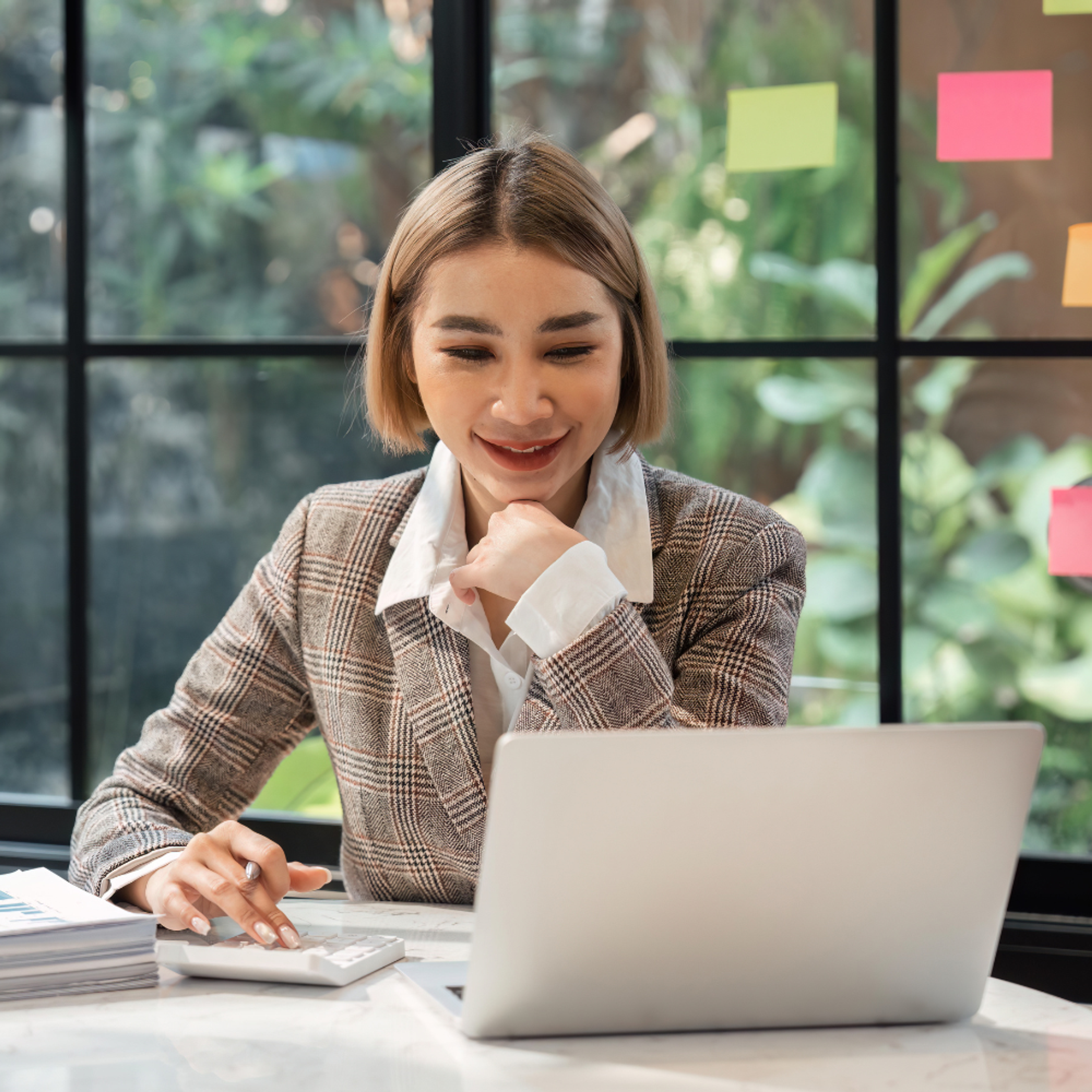 Accountant at laptop with post-it notes and calculator