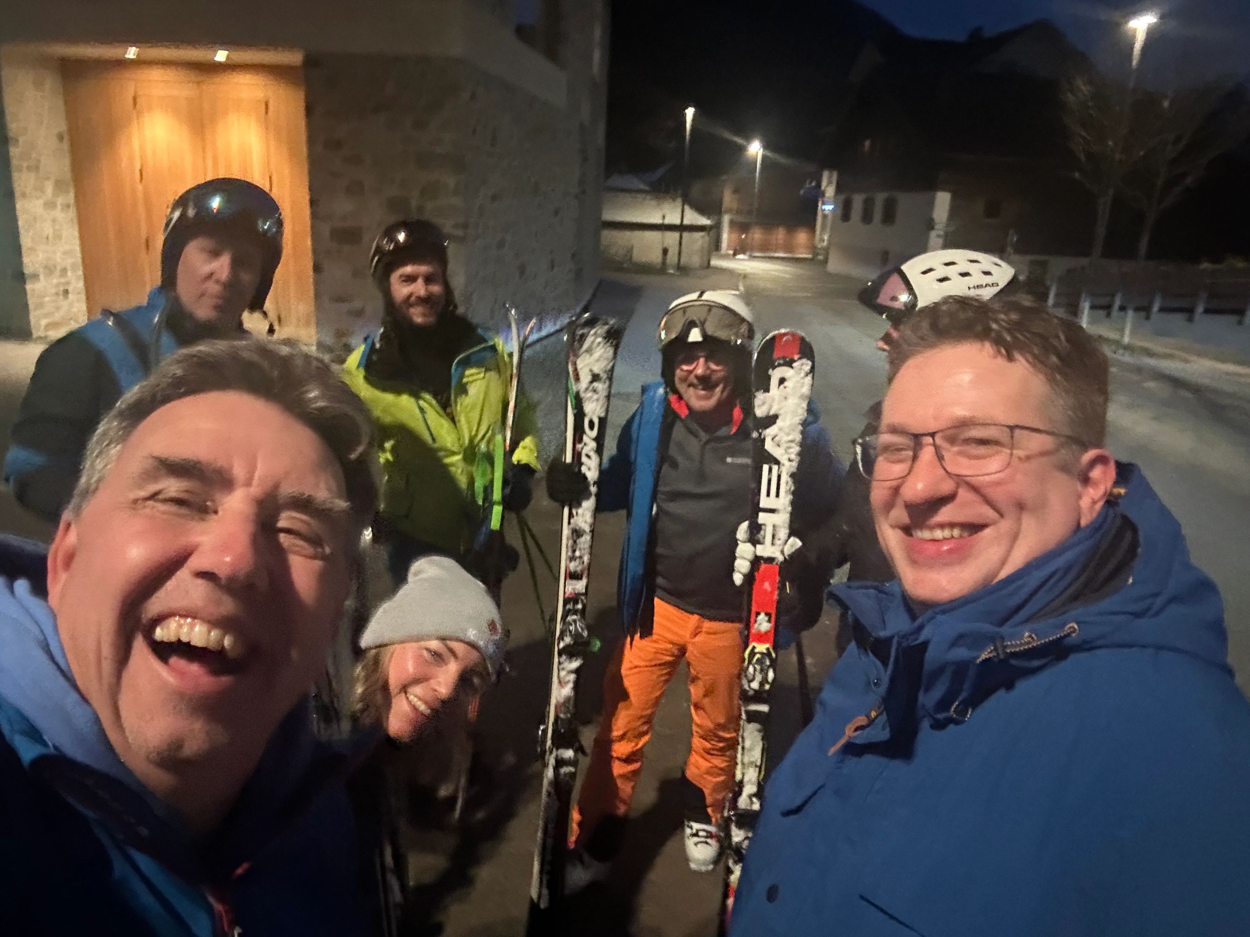Drei Kollegen mit Ski am Abend