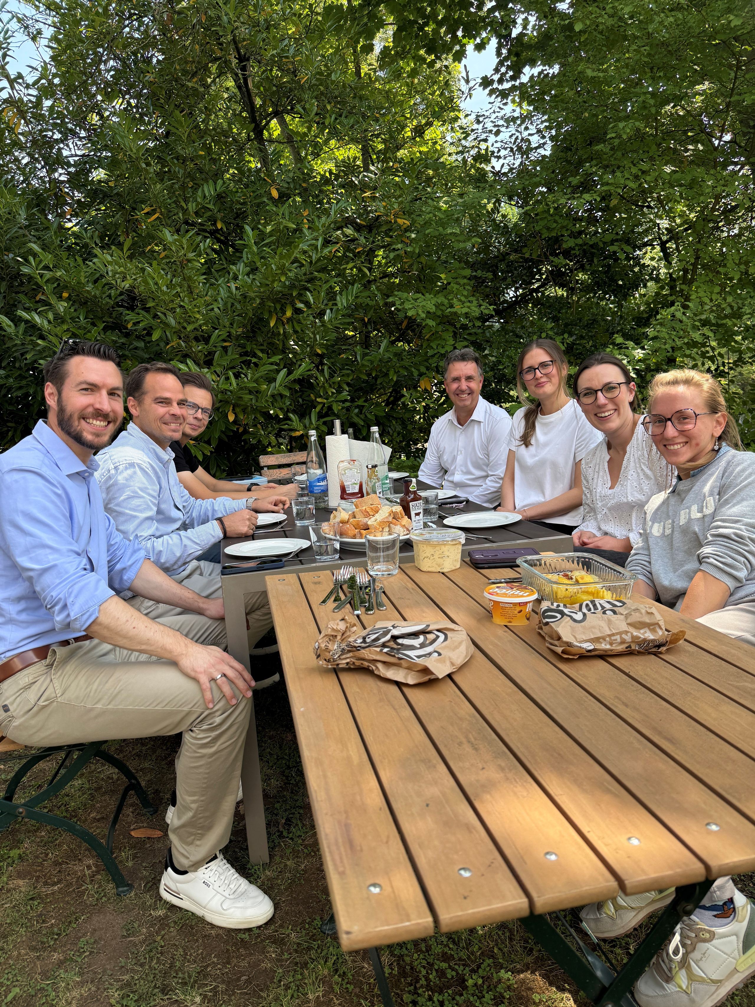 Kolleginnen und Kollegen am Gartentisch