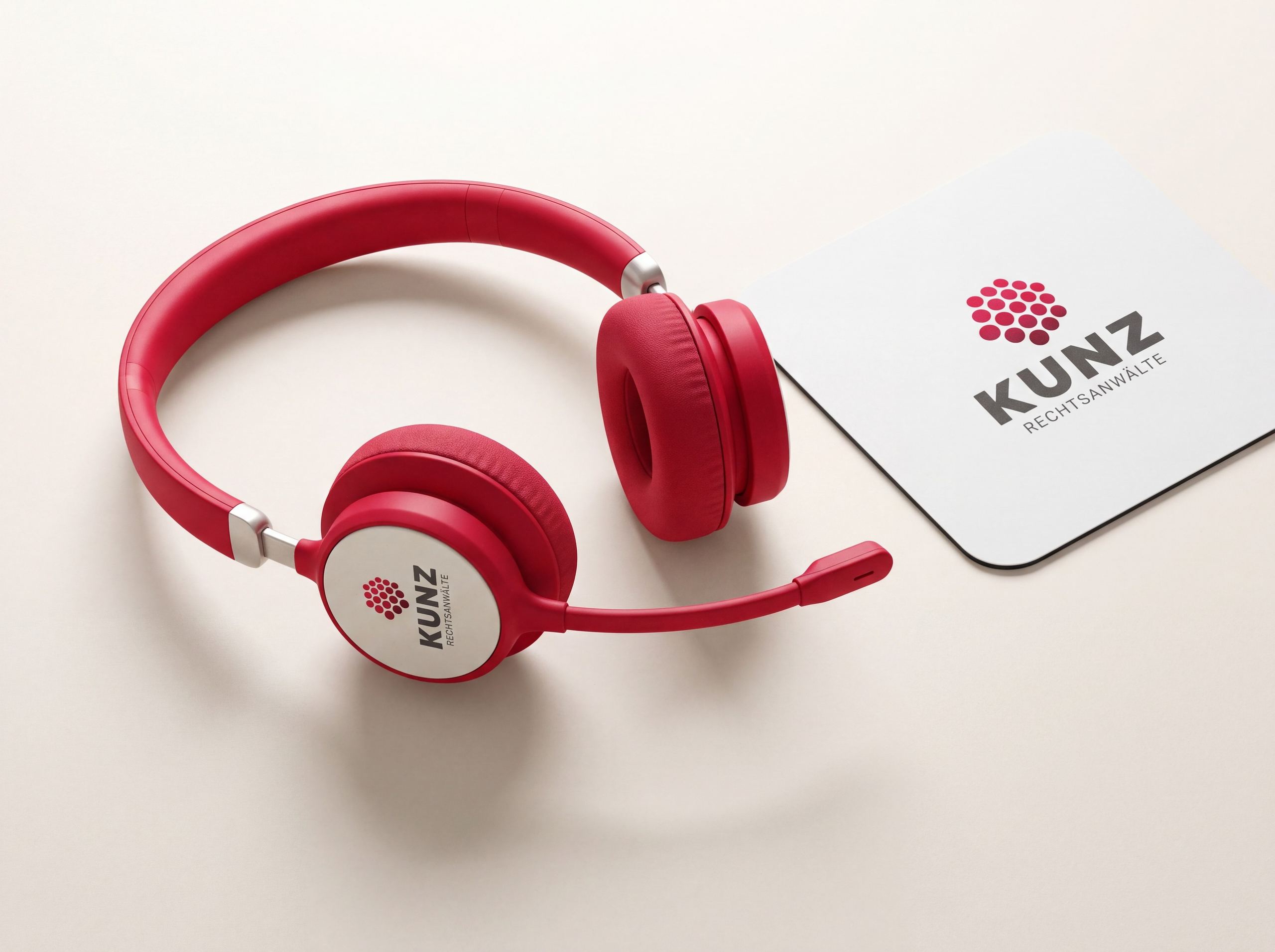 Rotes Headset mit KUNZ-Logo, daneben ein weißes Mousepad