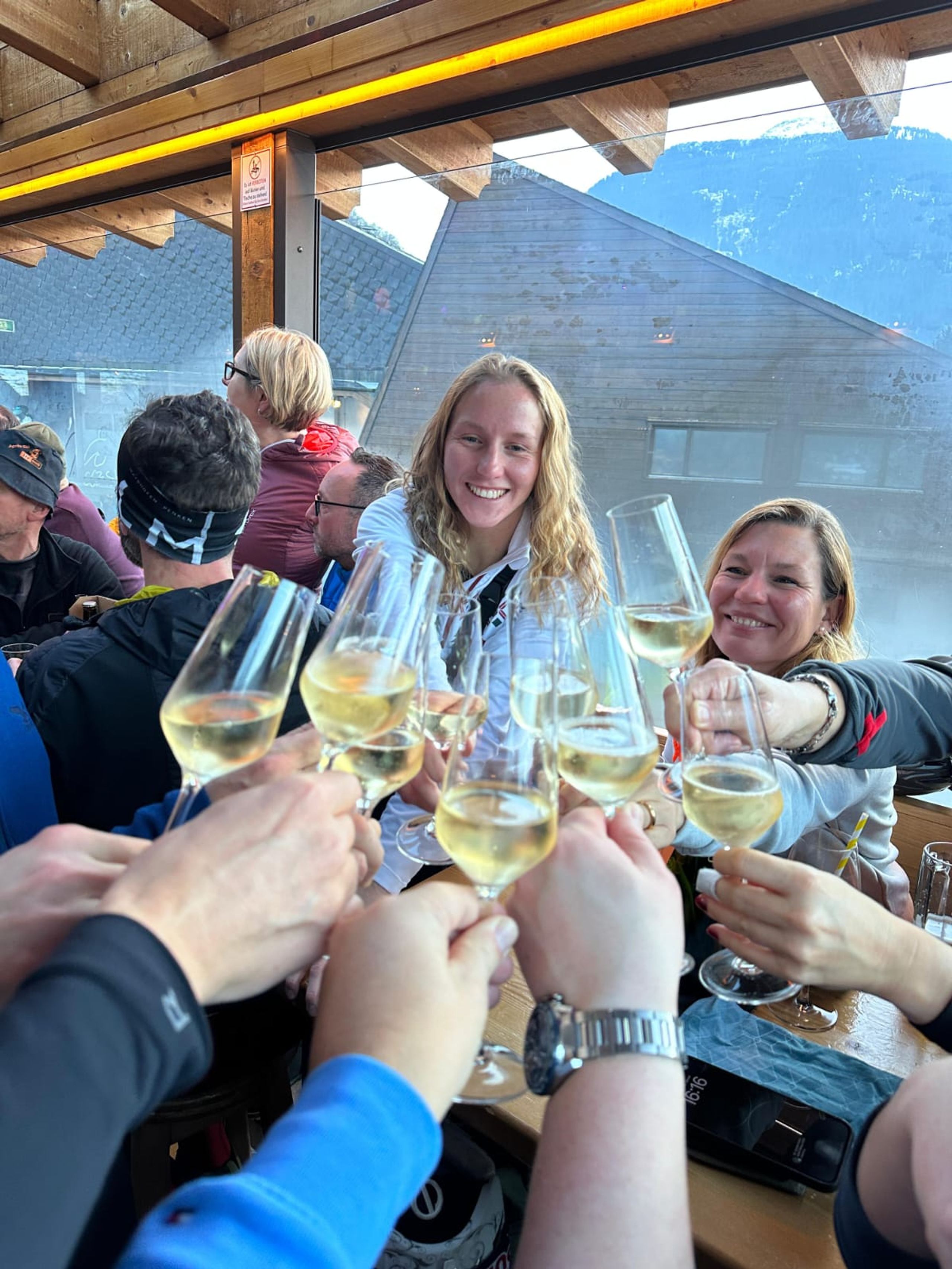 Anstoßen mit einem Glas Wein auf der Hütte