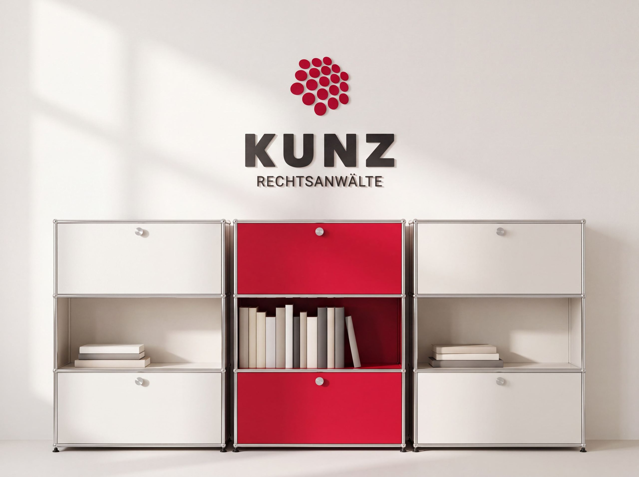 Helles Regalsystem mit rotem Mittelelement und Büchern, darüber das KUNZ-Logo