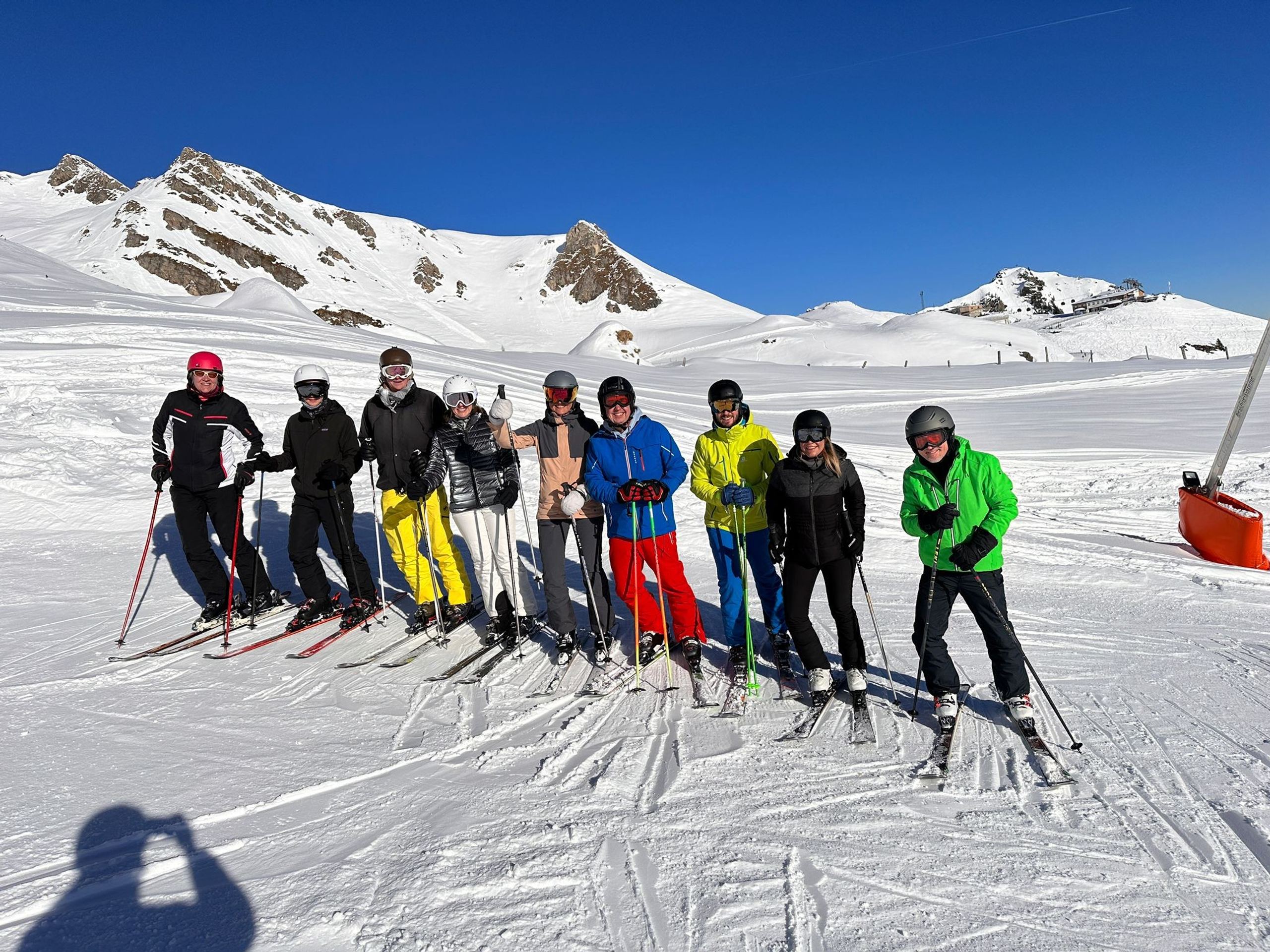 Die Gruppe aufgereiht auf Ski vor dem Bergpanorama