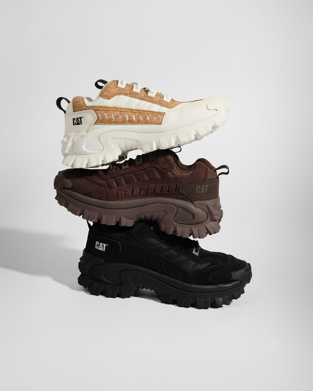 Stack of three Cat Footwear sneakers