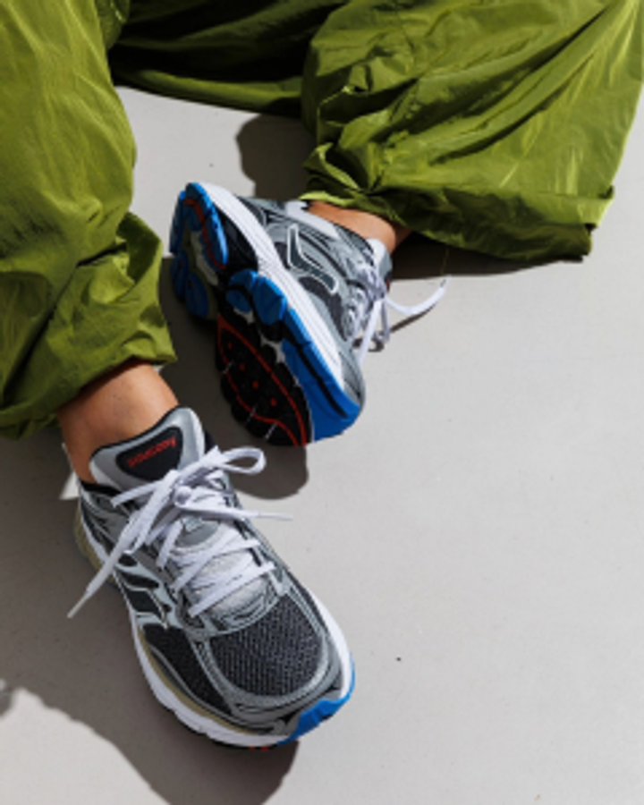 Grey trail running shoes on green trousers