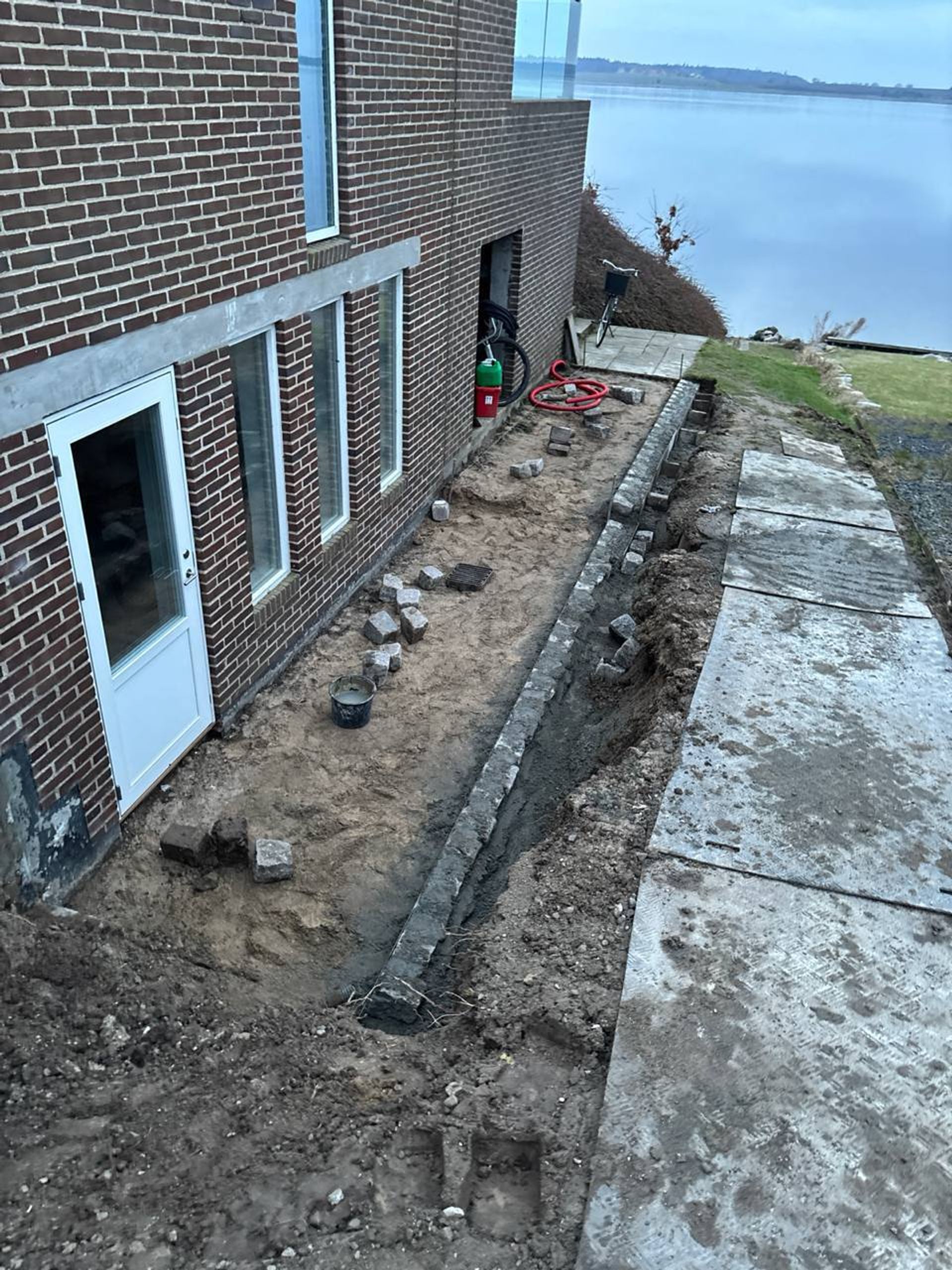 Granitbrosten i støttemur under arbejde ved vand