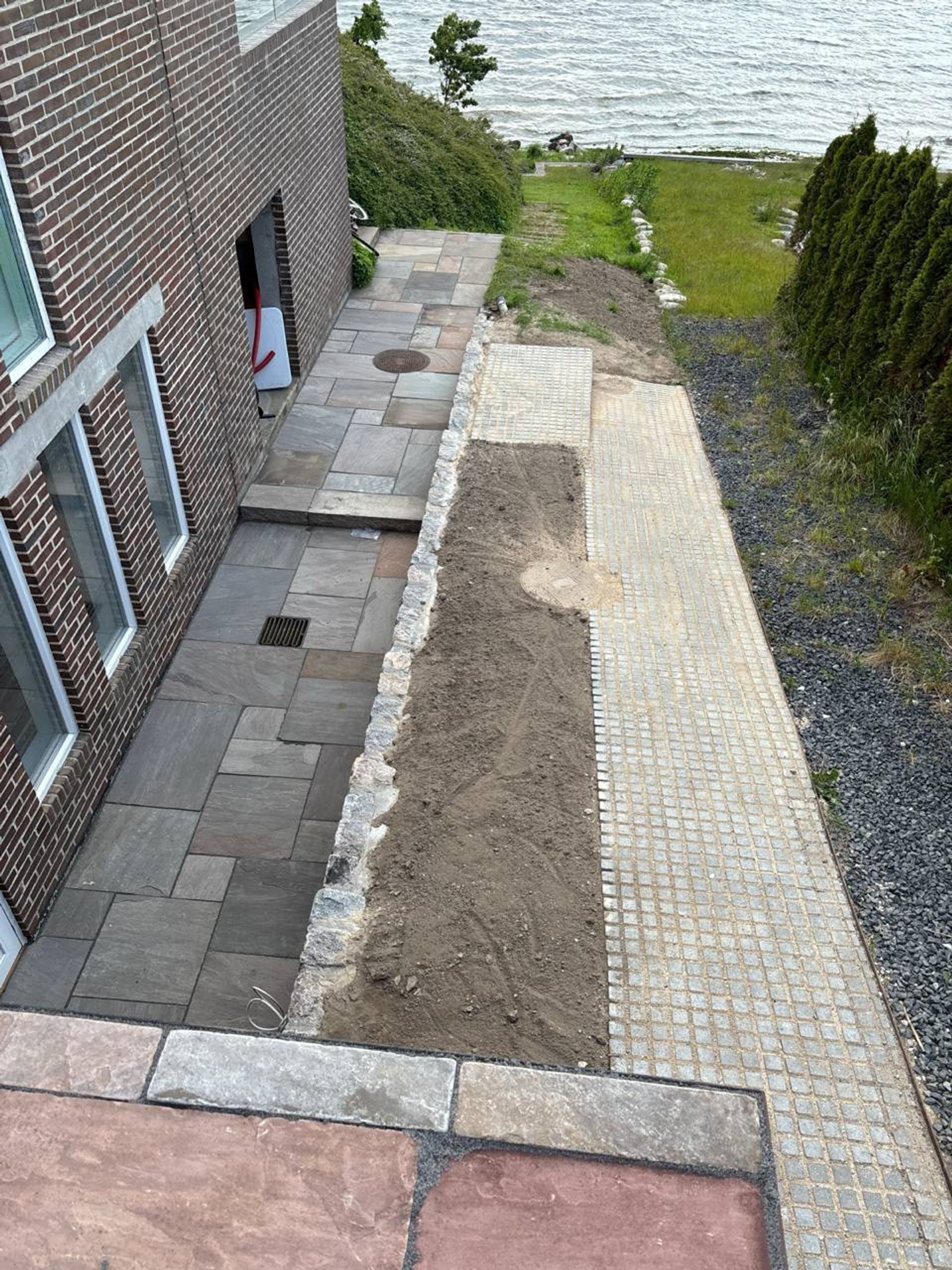 Sandstensbelægning ved bolig nær kysten