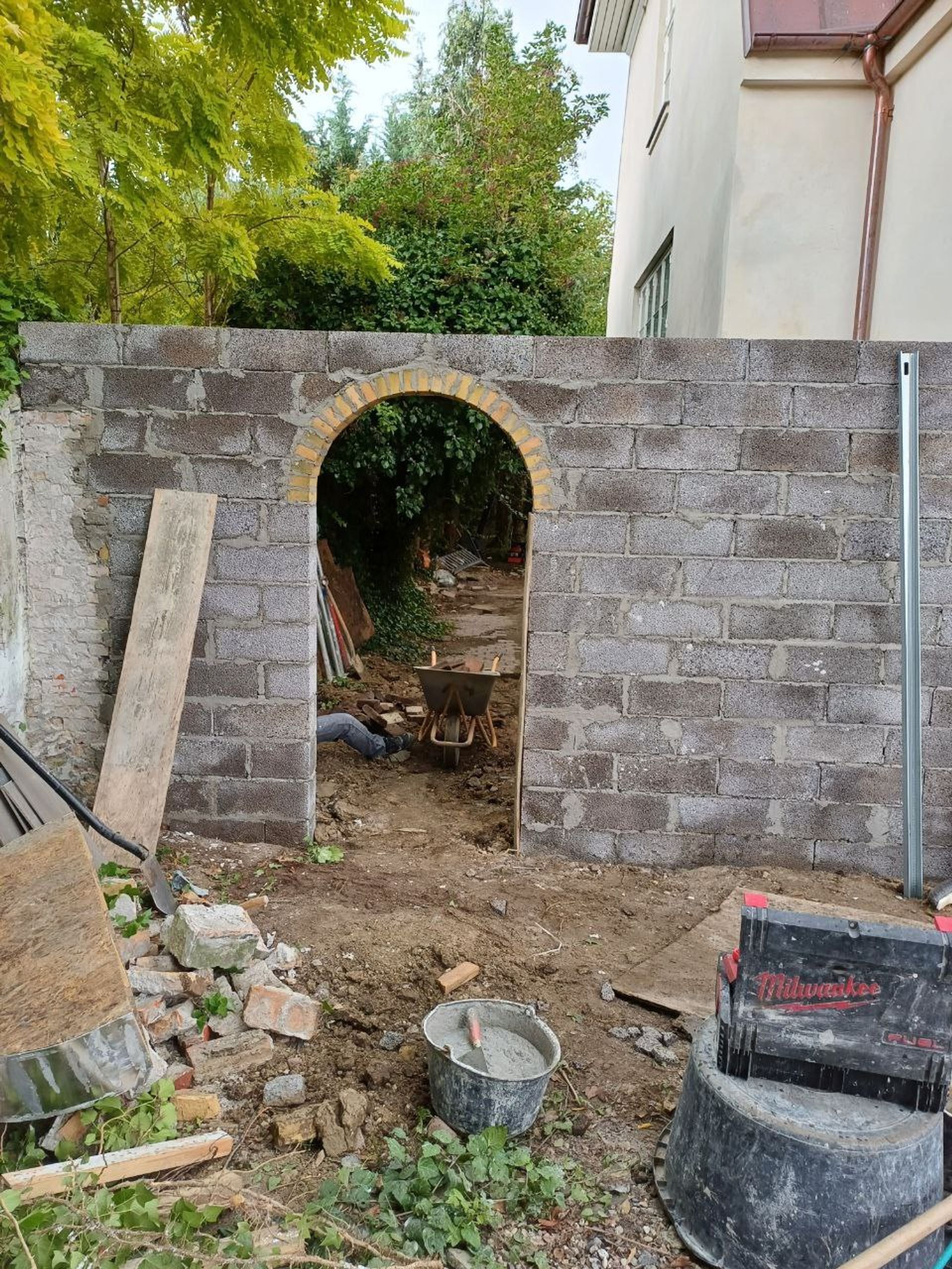 Facade før pudsning — mur med bueåbning under opbygning