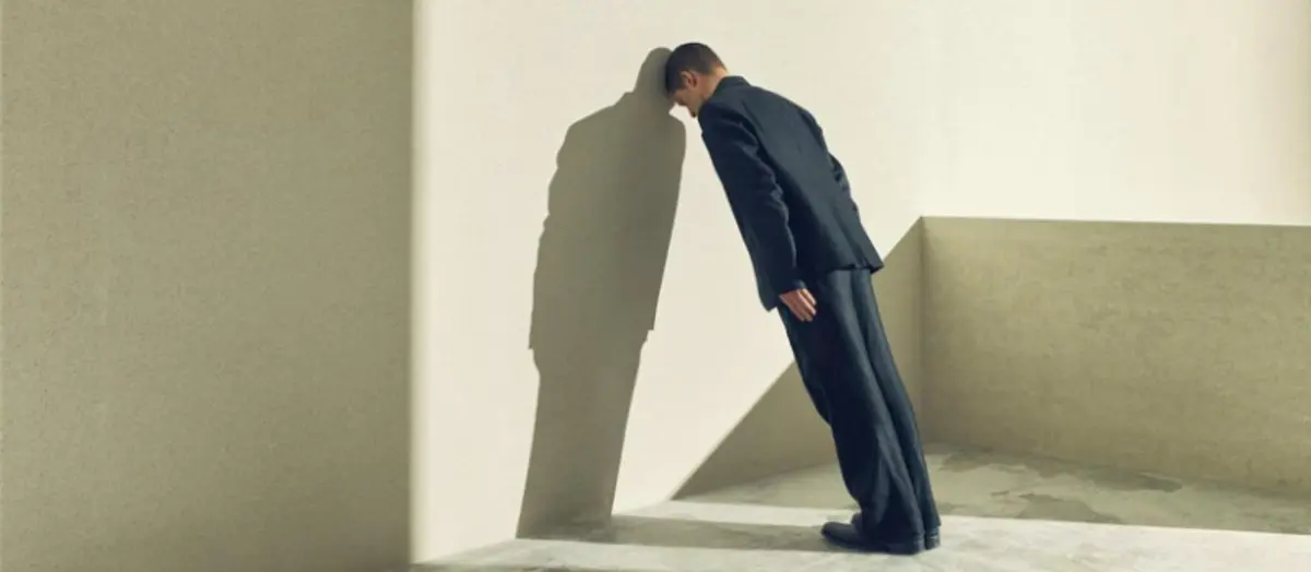 The piece of Boris Godoenov, it's a man in suit leaning head against wall, casting shadow in minimal space