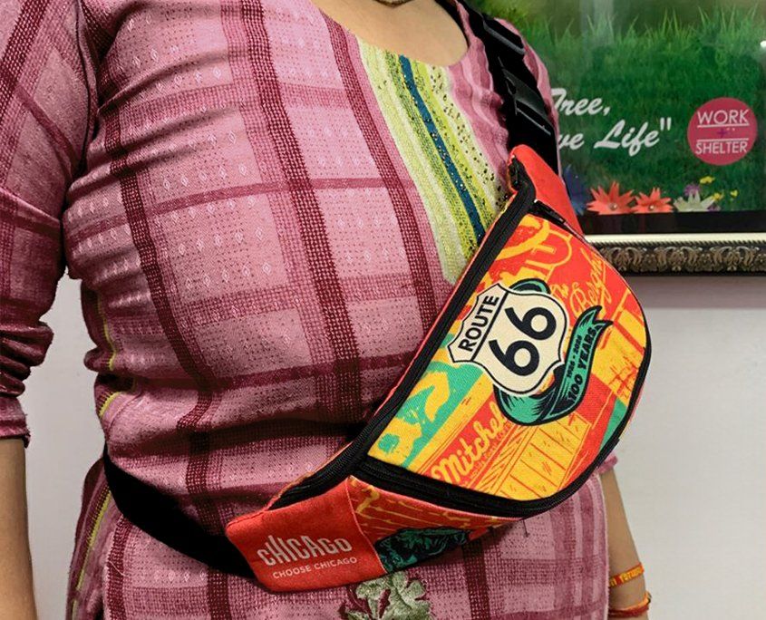 Pregnant woman wearing pink checkered shirt with Route 66 colorful fanny pack.