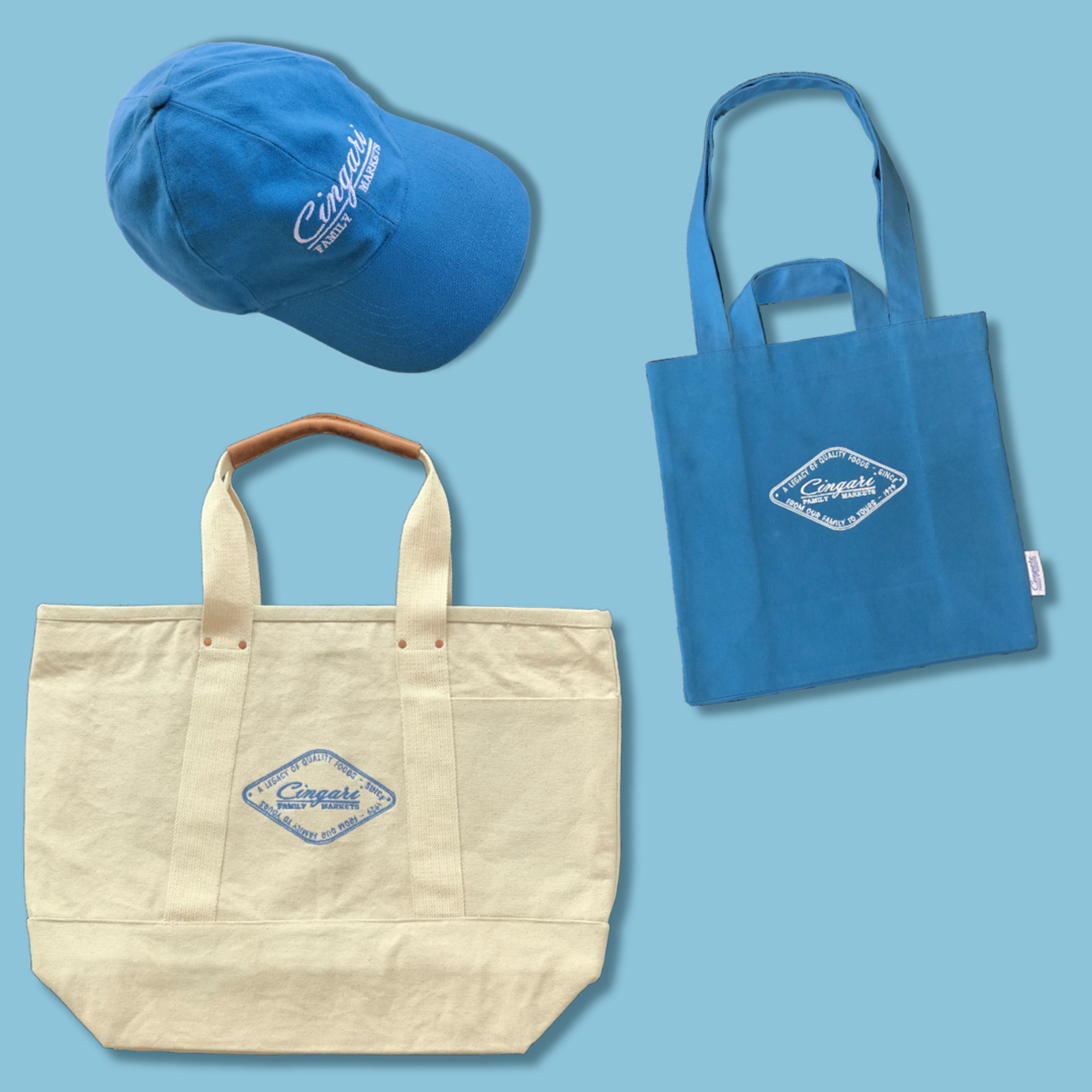 Blue baseball cap and two canvas tote bags with Cuyahoga branding on light blue background.