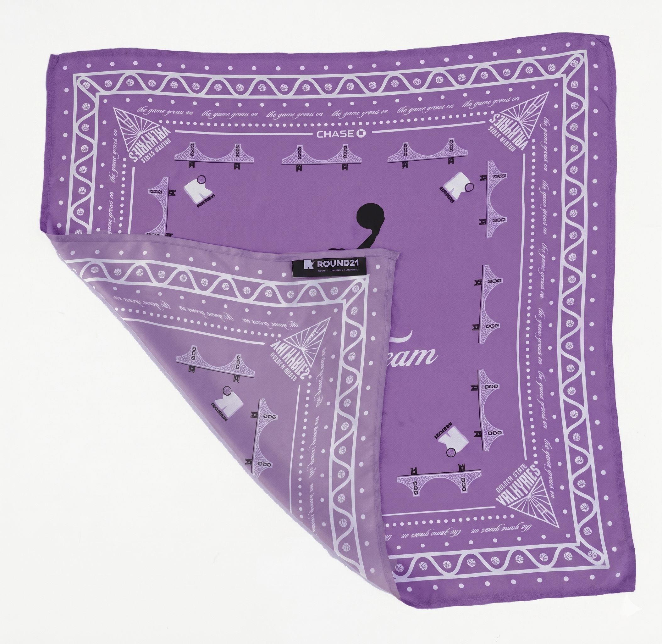Lavender silk scarf featuring a black silhouette of a female basketball player dunking, titled 'The Bay's Team.' The design includes white Golden Gate Bridge icons, Golden State Valkyries logos in the corners, and a decorative patterned border.