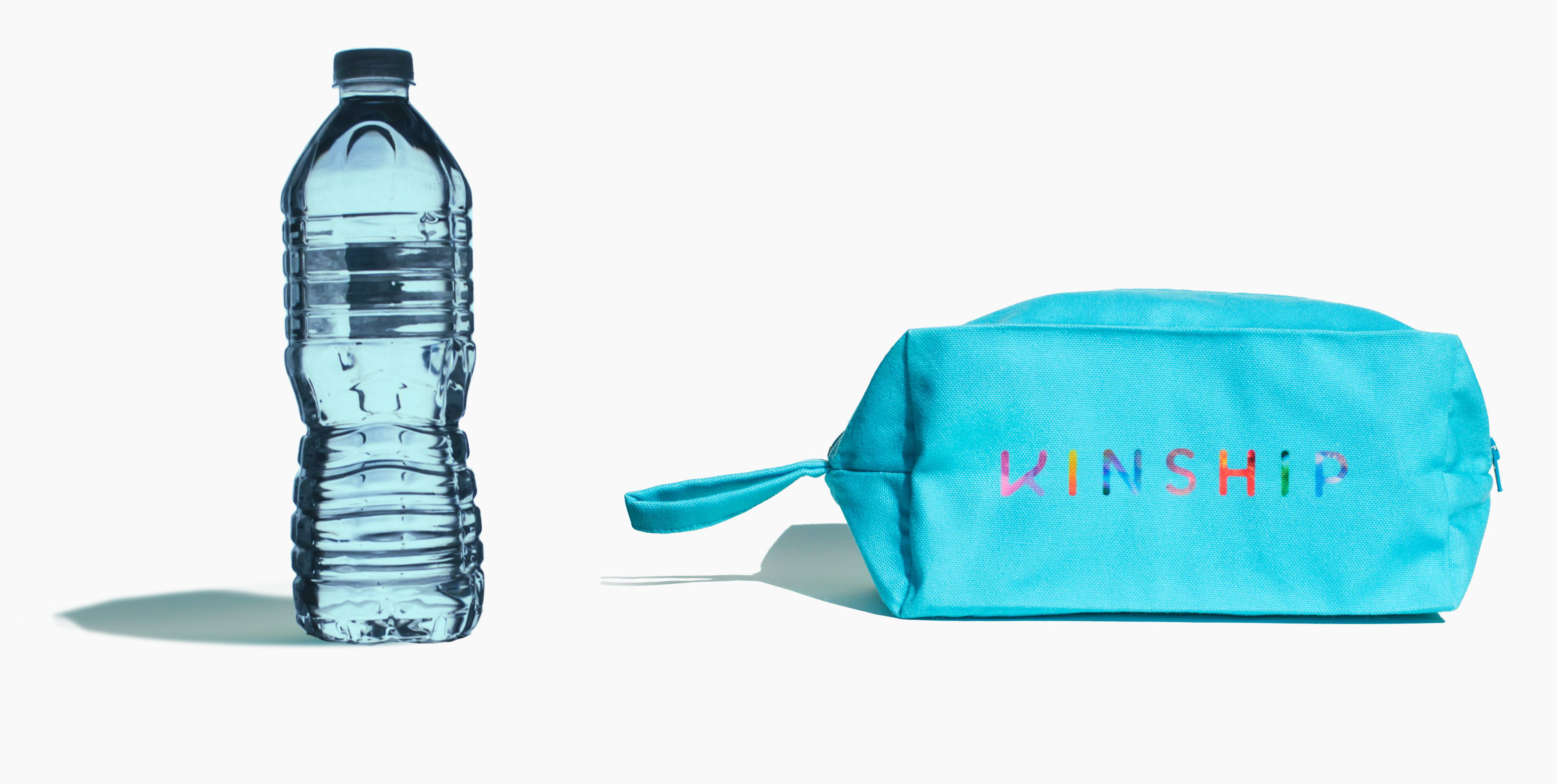 Plastic water bottle and turquoise Kinship toiletry bag on white background.