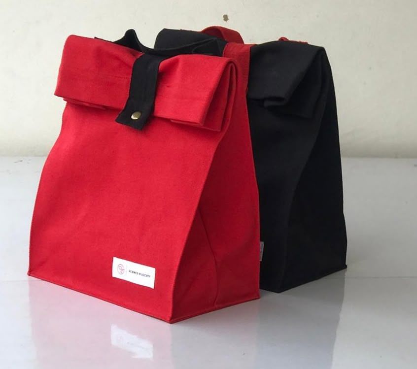 Two fabric lunch bags, one red and one black, displayed on white surface.