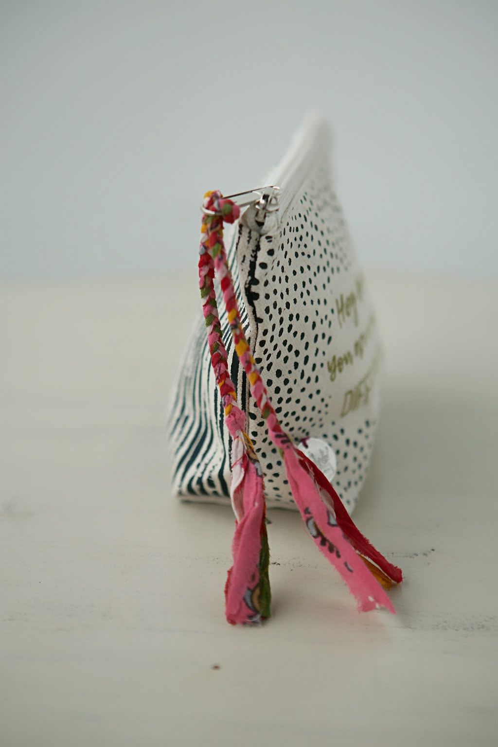 Colorful ribbon bookmark attached to white perforated book or object.