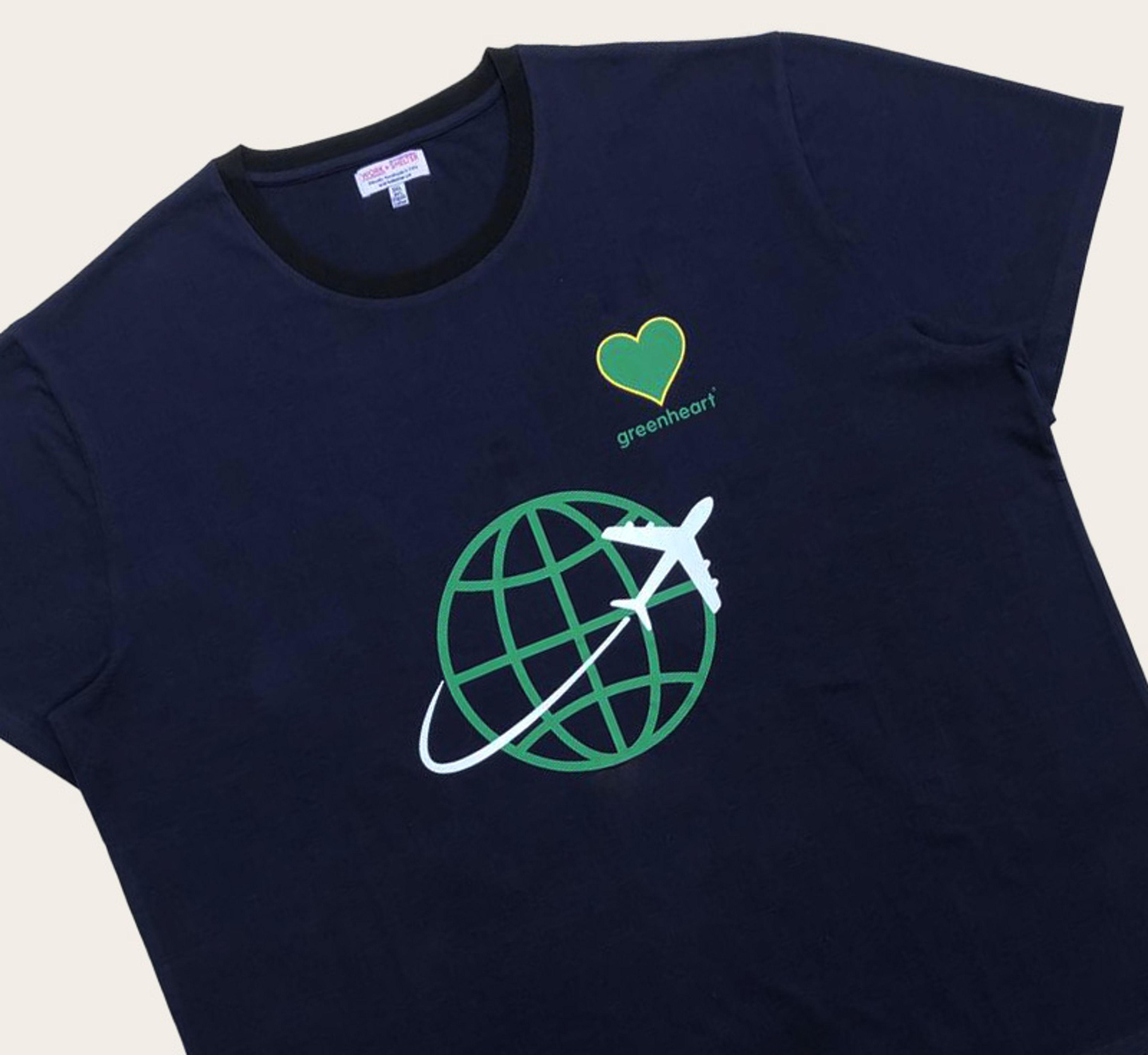 Navy t-shirt with green heart, globe, and airplane design featuring "greenheart" text.