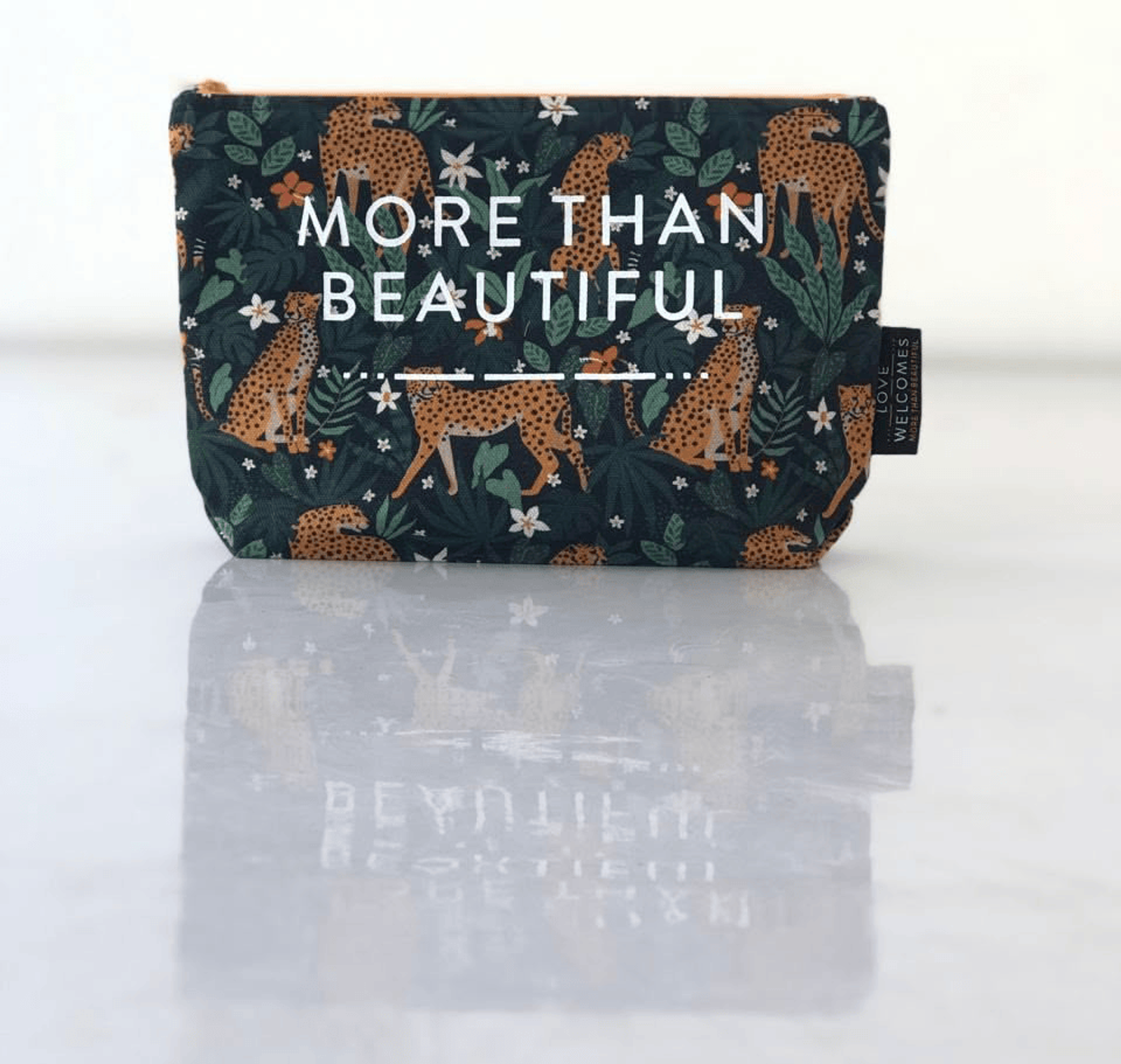 Dark cosmetic pouch with leopard pattern and "More Than Beautiful" text displayed.
