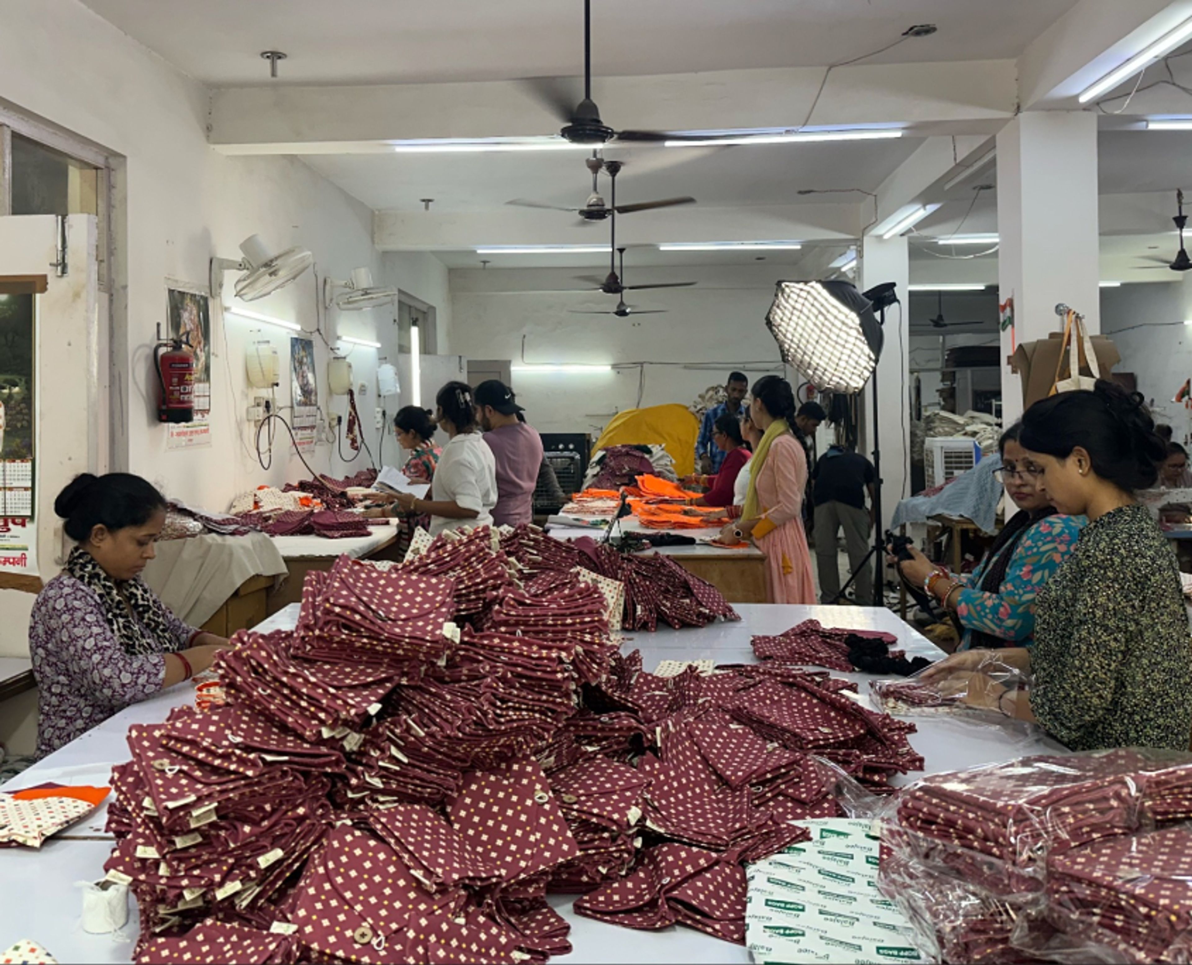 Artisans at Work+Shelter placing finished pouches into eco-friendly cellophane packaging.
