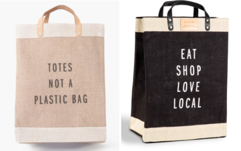 Two reusable tote bags with text messages promoting eco-friendly and local shopping.