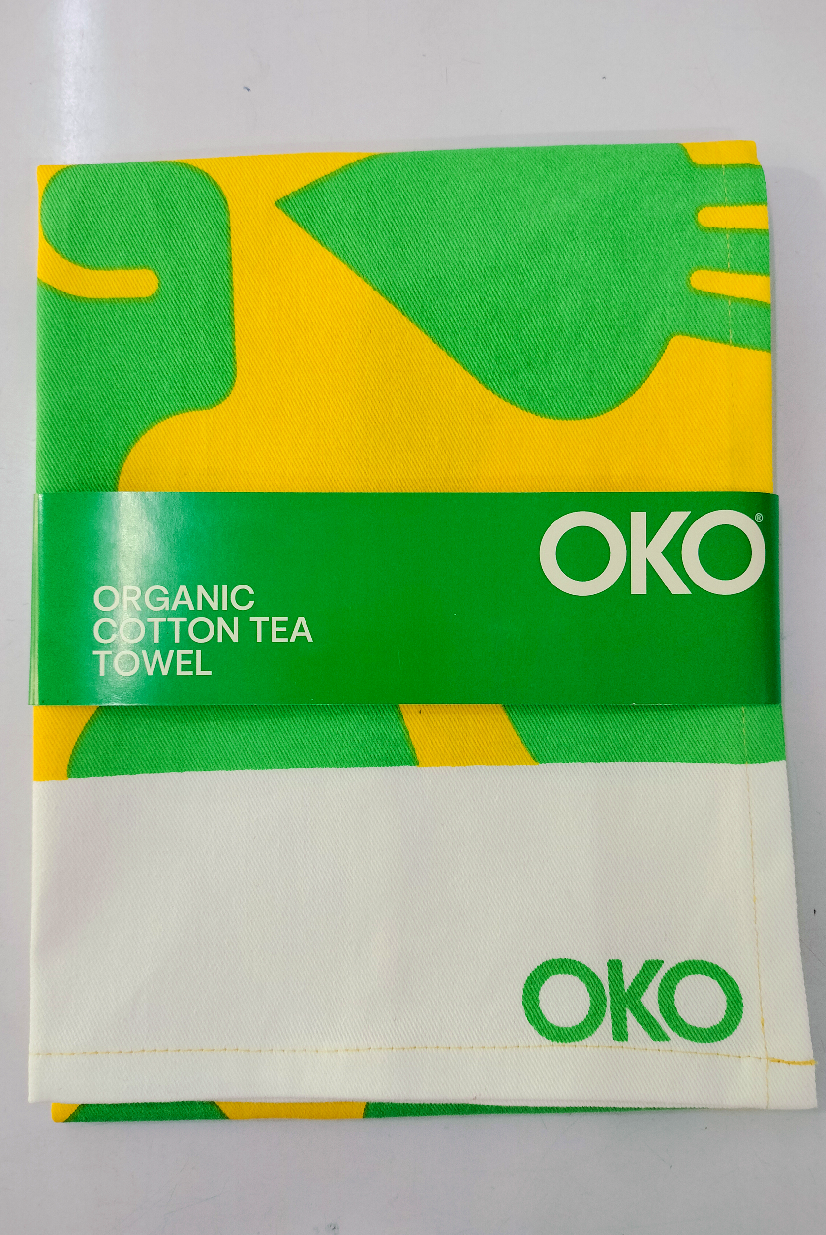 OKO organic cotton tea towel with green and yellow wavy pattern design.