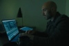 David Lowery, director of the movie The Green Knight, working on a laptop showing the Premiere Pro integration user interface.