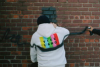 Man in vice hoodie spray-painting wall