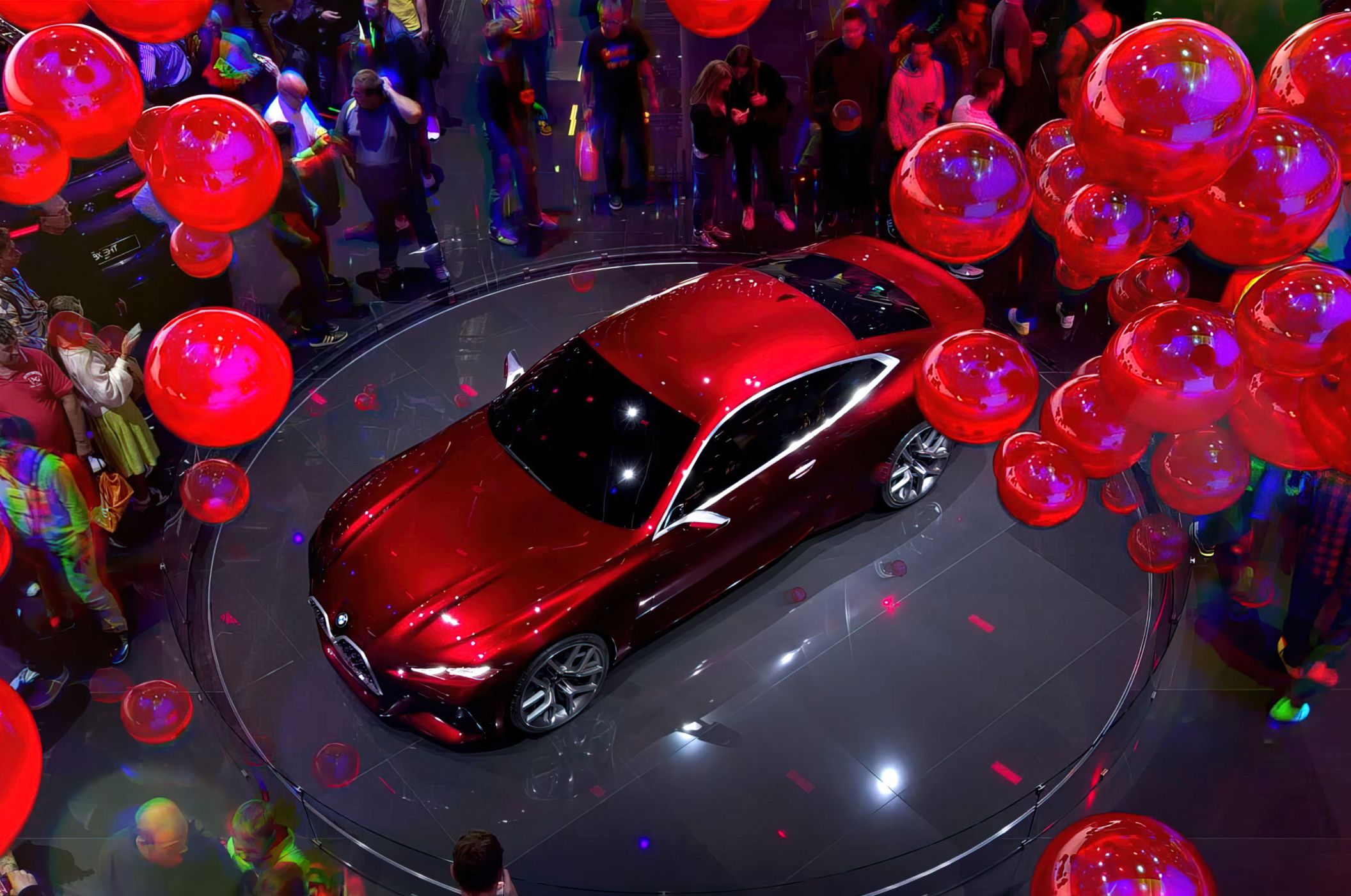 Car on display surrounded by balloons.