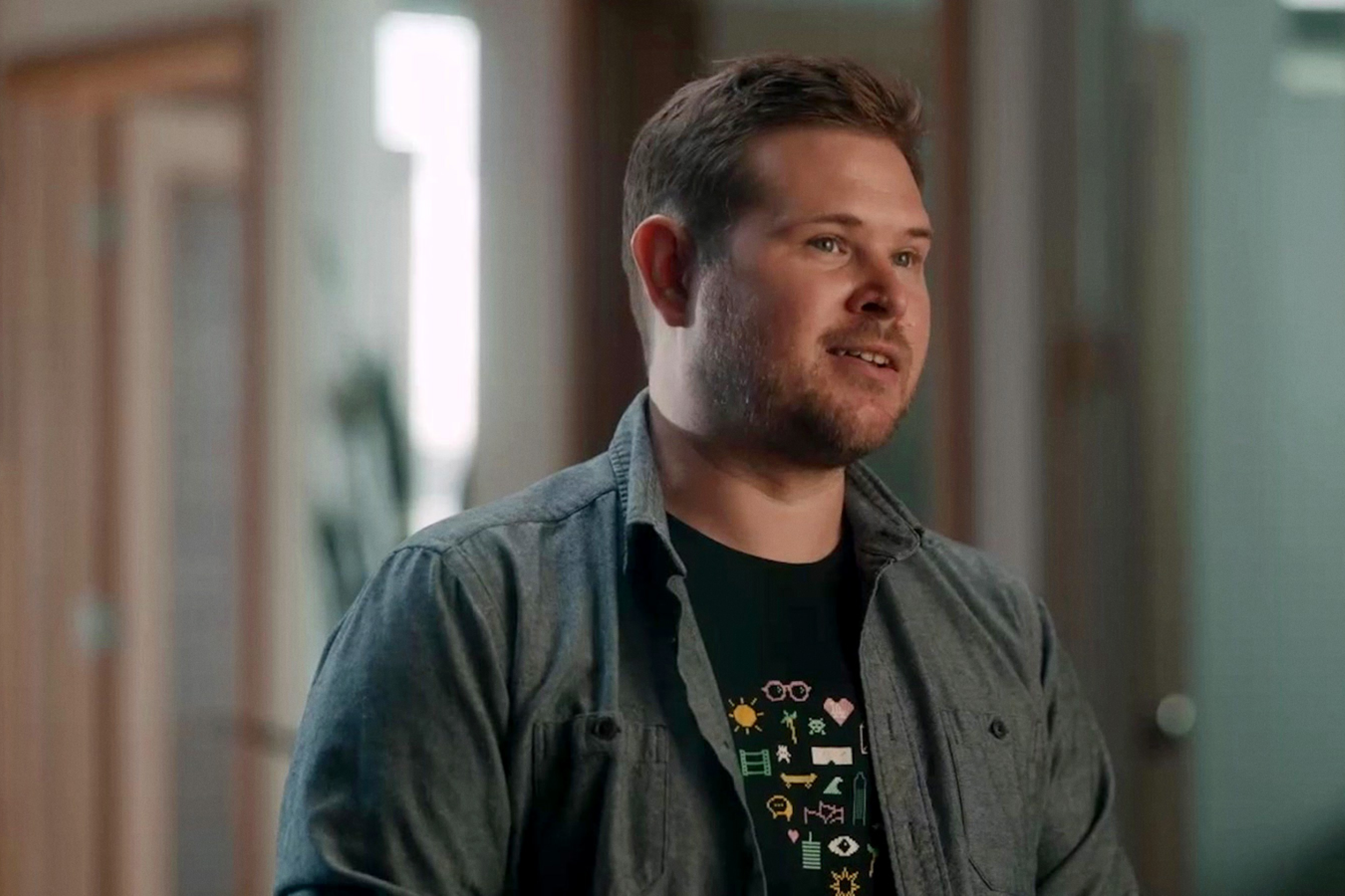 Tyler Hymanson, a post production supervisor, stand in a hallway. 