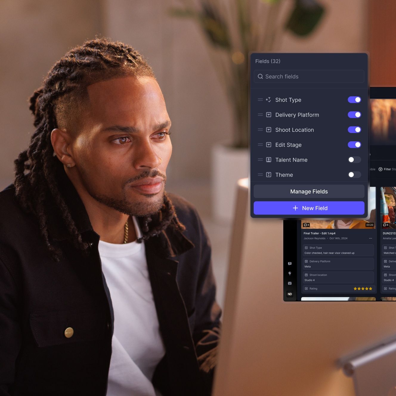 A man with dreadlocks looks at a computer screen displaying a content management interface with "Fields" options.
