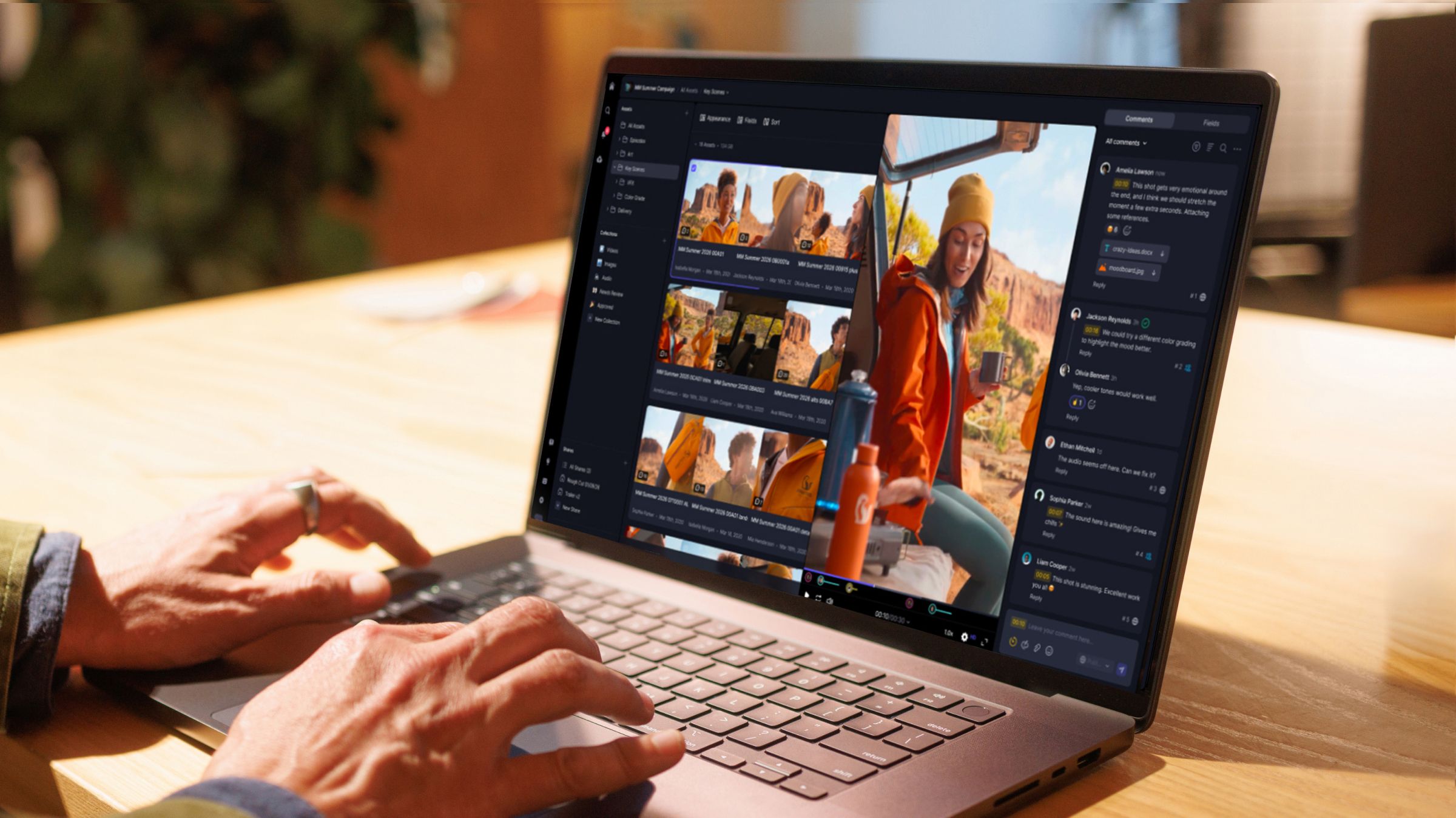 Hands typing on a laptop displaying a video review interface with a woman in an orange jacket outdoors.