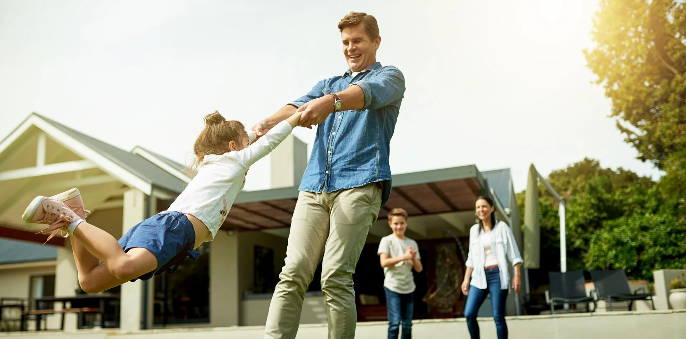 A family playing together in the yard outside their home