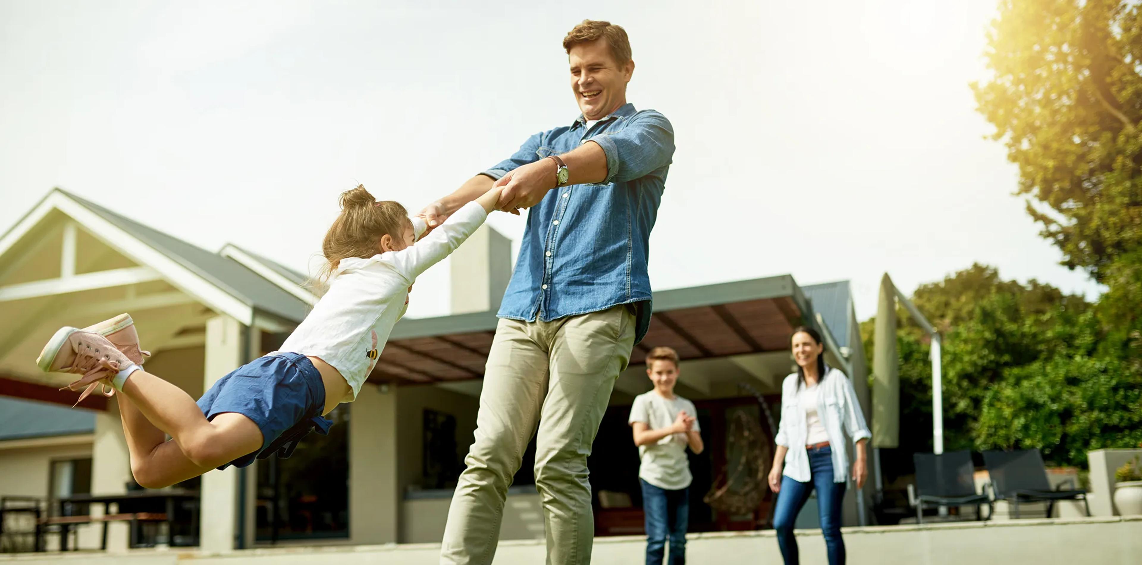A family playing together in the yard outside their home
