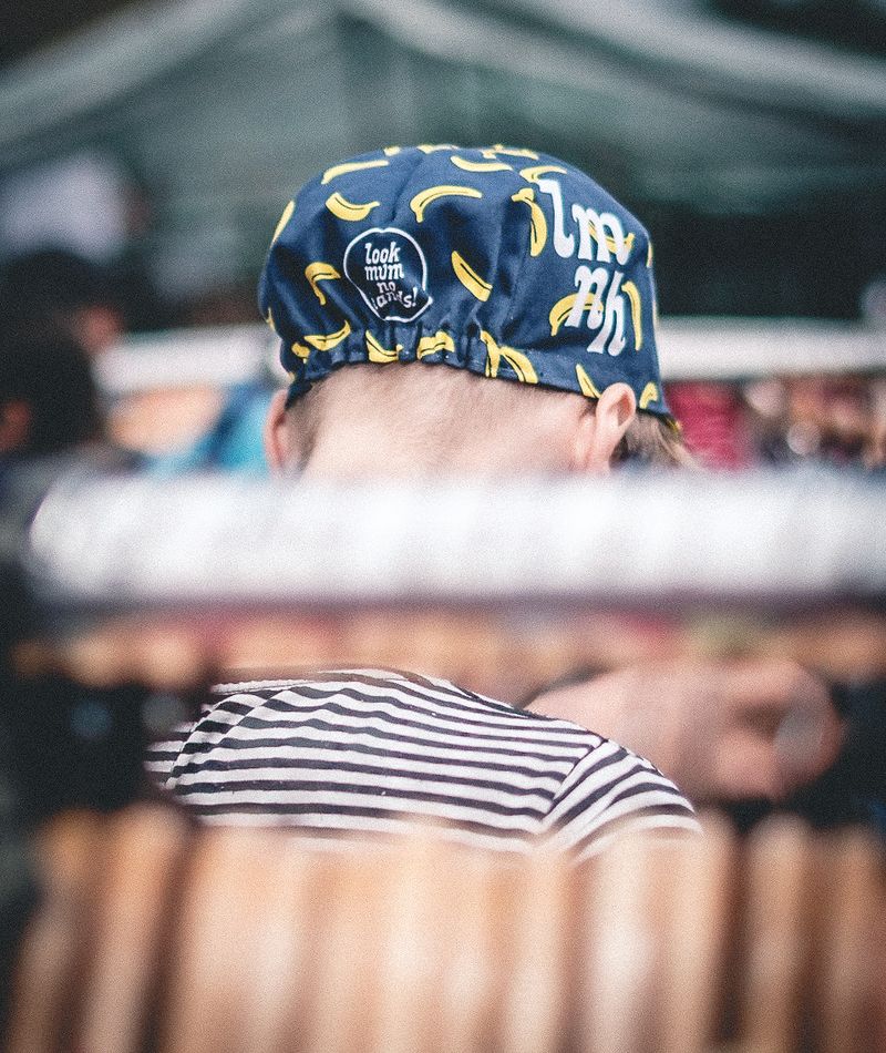 A man in a cycling cap covered in bananas and the words 'look mum no hands!'