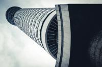 The London BT Tower seen from the ground, at a forty-five degree angle, looking a bit like a dalek.