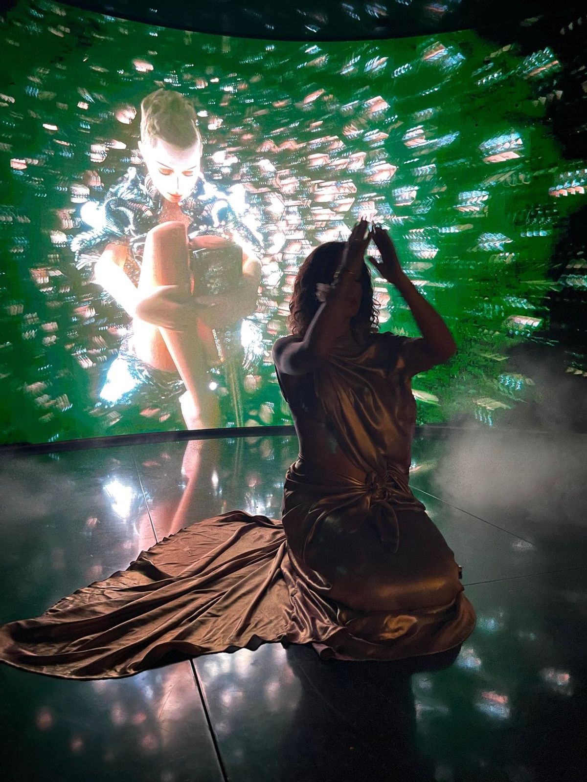 Aimée Sophia seated before an immersive LED installation