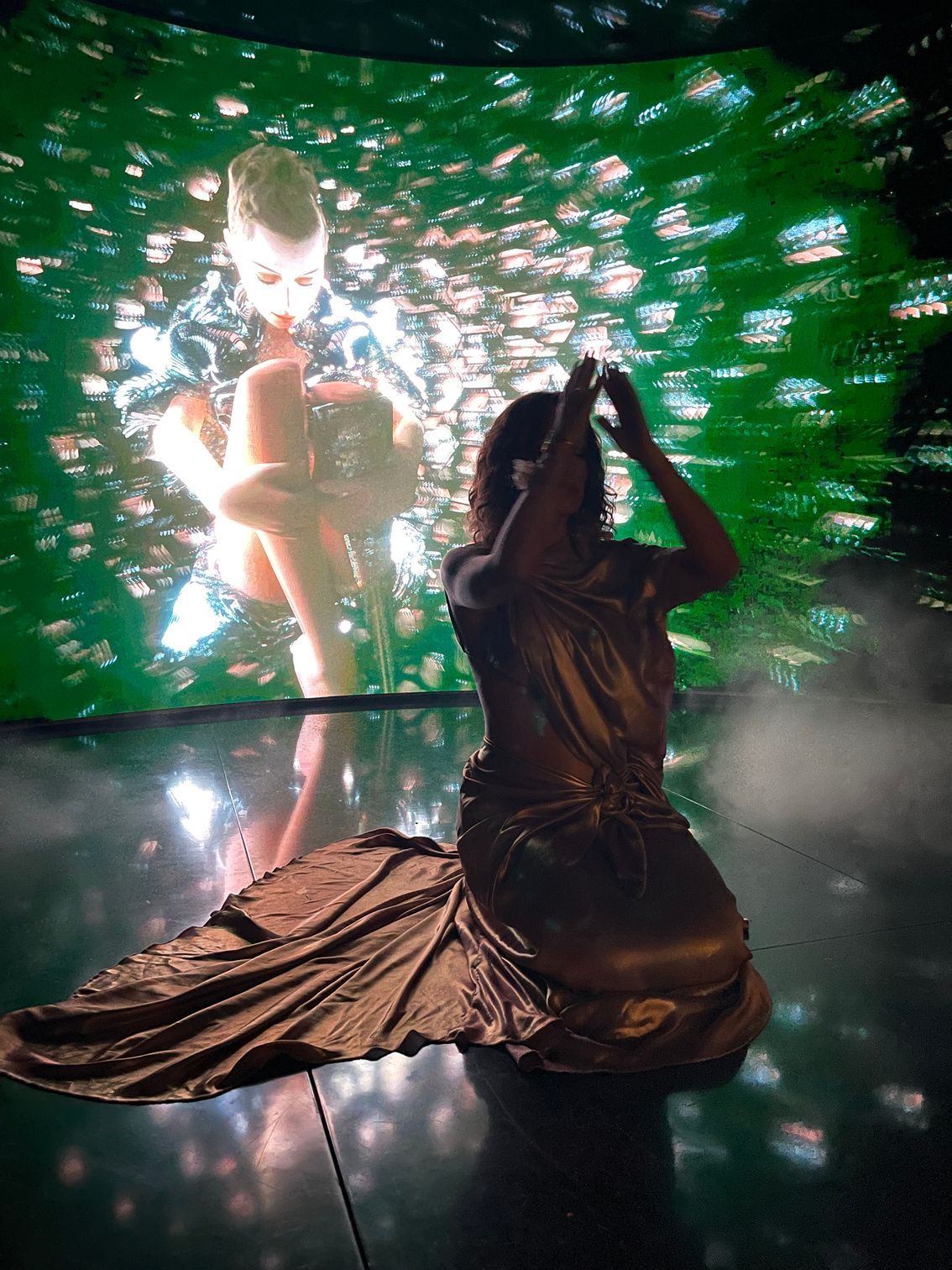Aimée Sophia seated before an immersive LED installation
